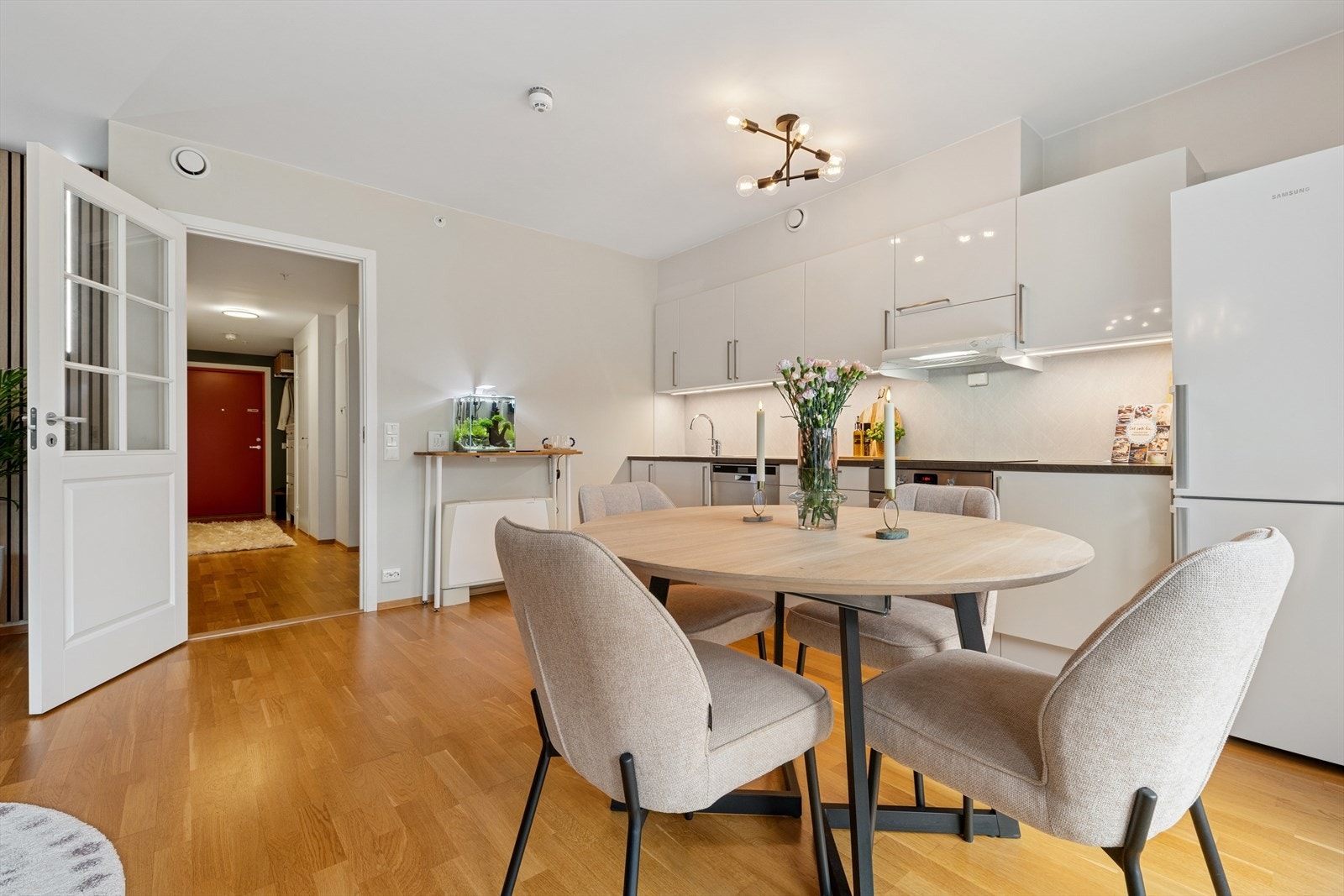 Det er god plass til både stor sittegruppe og spisebord i den åpne stue- og kjøkkenløsningen, som gir en sosial og moderne ramme for hverdagsliv og gjestebesøk. Galleribilde