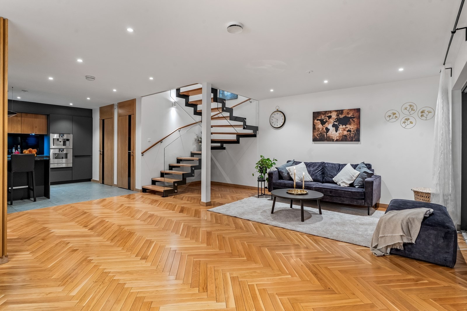 Stilren stue med moderne trapp som et naturlig blikkfang - lekkert og gjennomført. Galleribilde