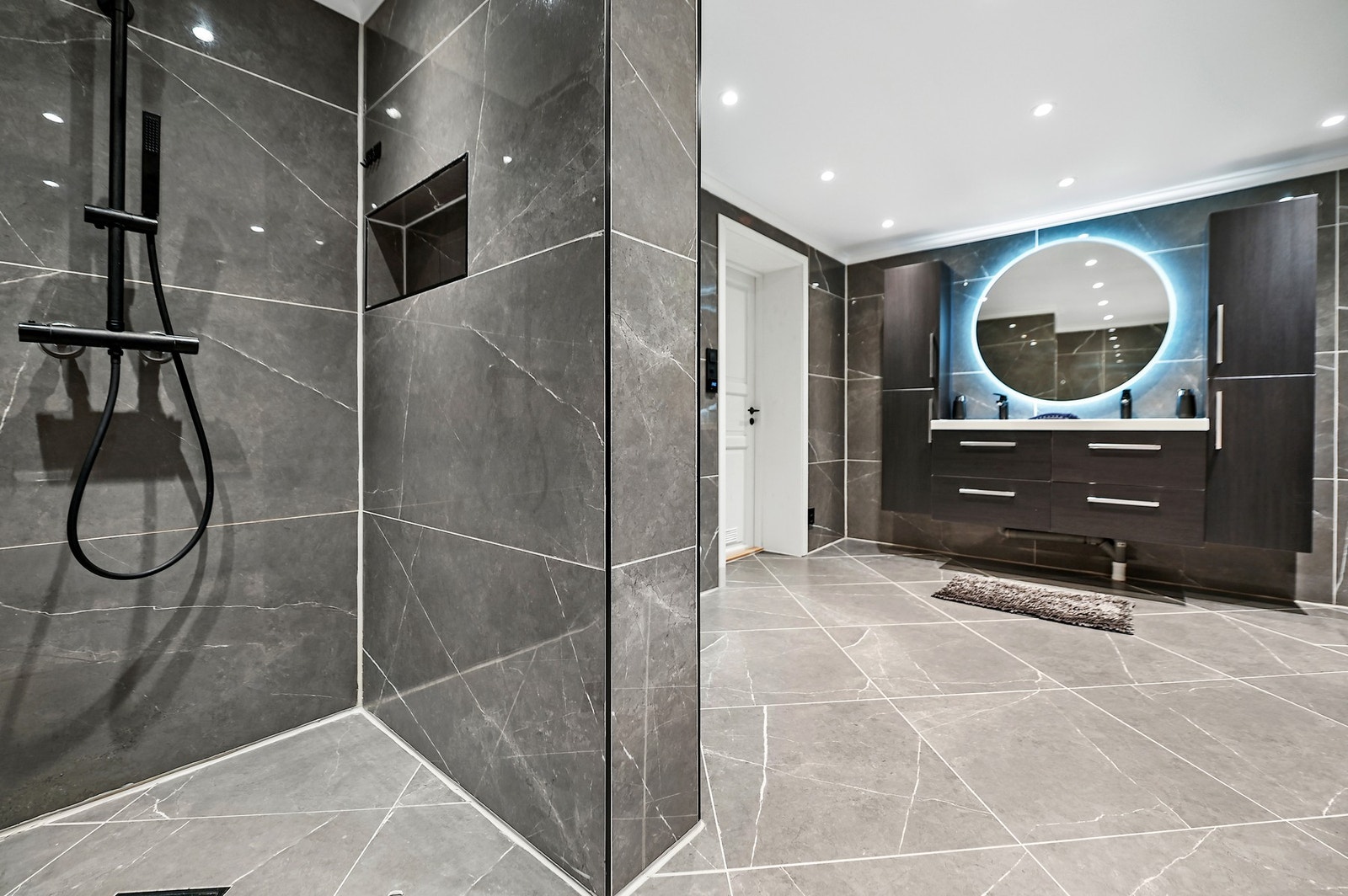 Rommet har innredning med to nedfelte servanter, veggfestet toalett, badekar og dusjhjørne. Galleribilde