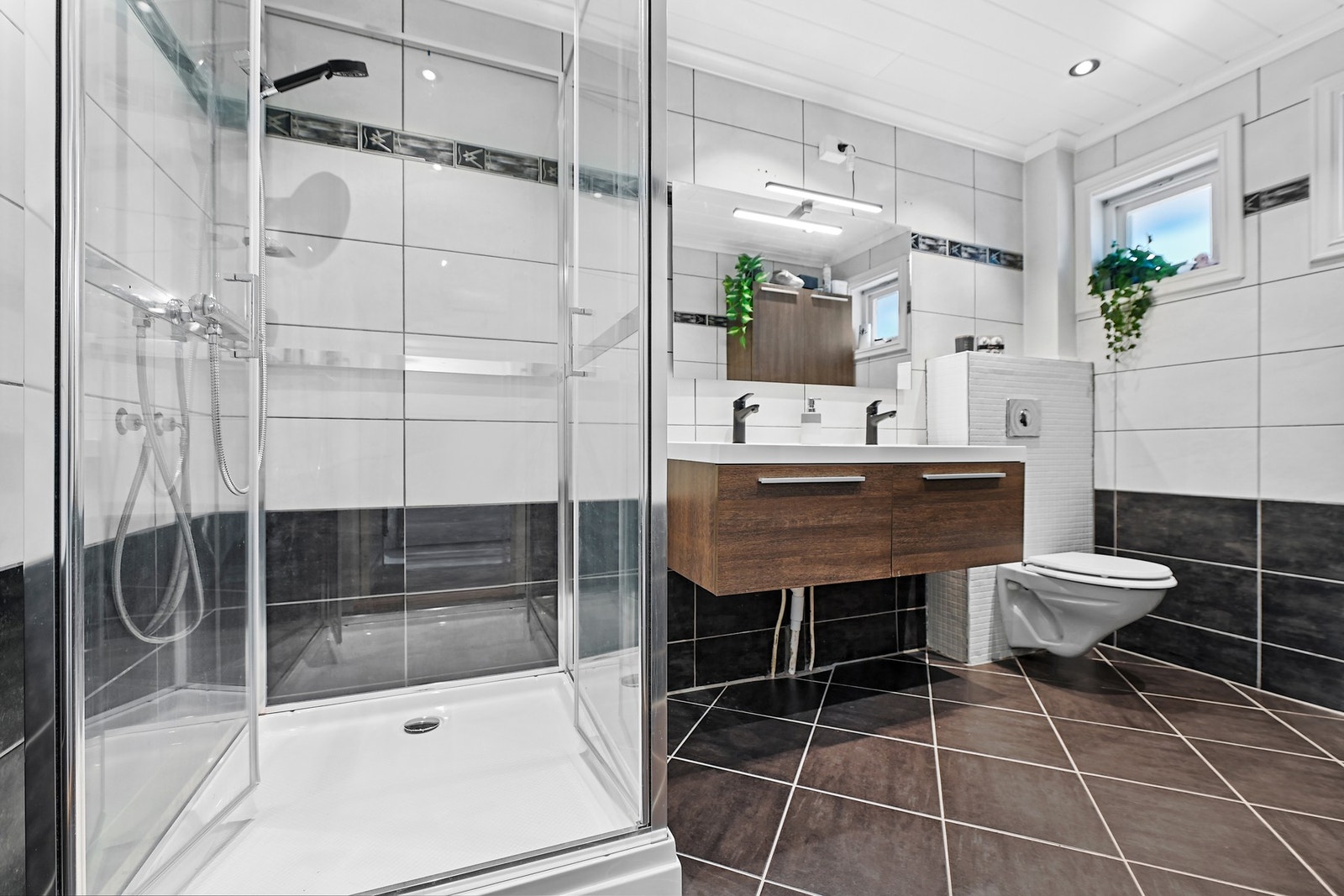 Badet i 1. etasje er innredet med to nedfelt servanter, veggfestet toalett og dusjkabinett. Galleribilde