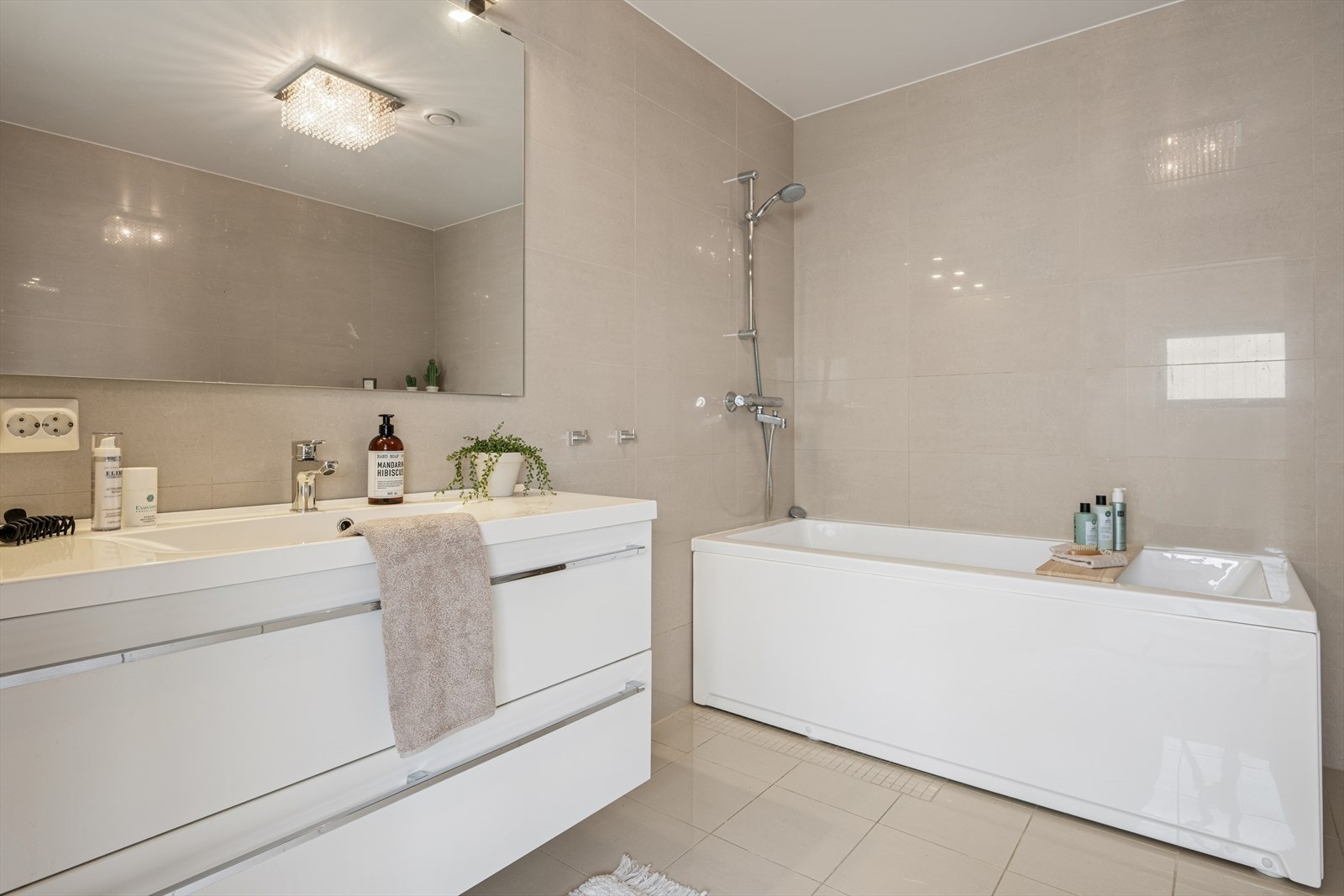 Badet i andre etasje er delikat innredet med beige fliser på gulv og vegger. I gulvet har man også vannbåren varme. Galleribilde