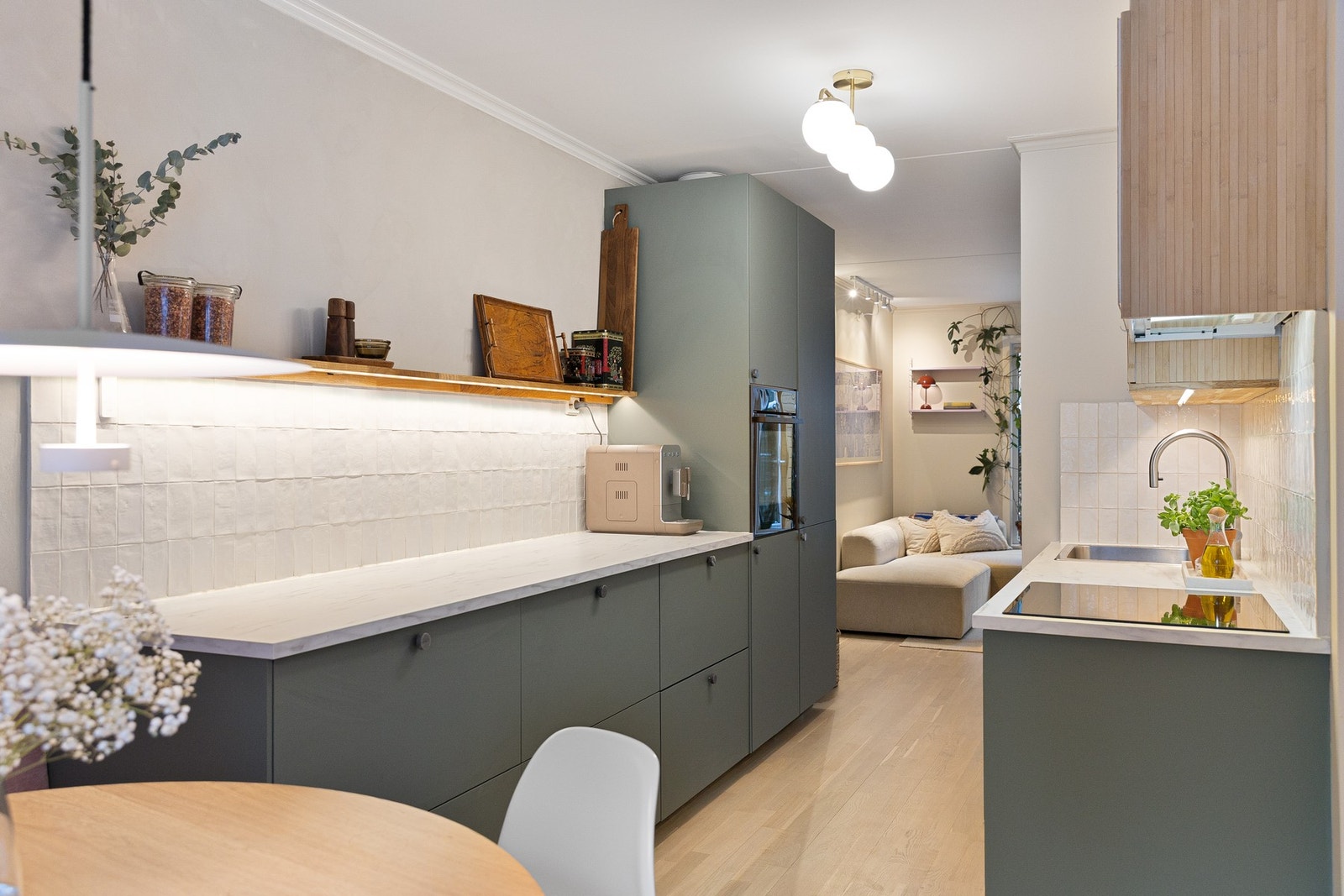 Innredningen er fra IKEA med glatte fronter som gir et stilrent og helhetlig uttrykk, kombinert med laminert benkeplate og fliser over benk for et praktisk og lettstelt arbeidsområde. Galleribilde