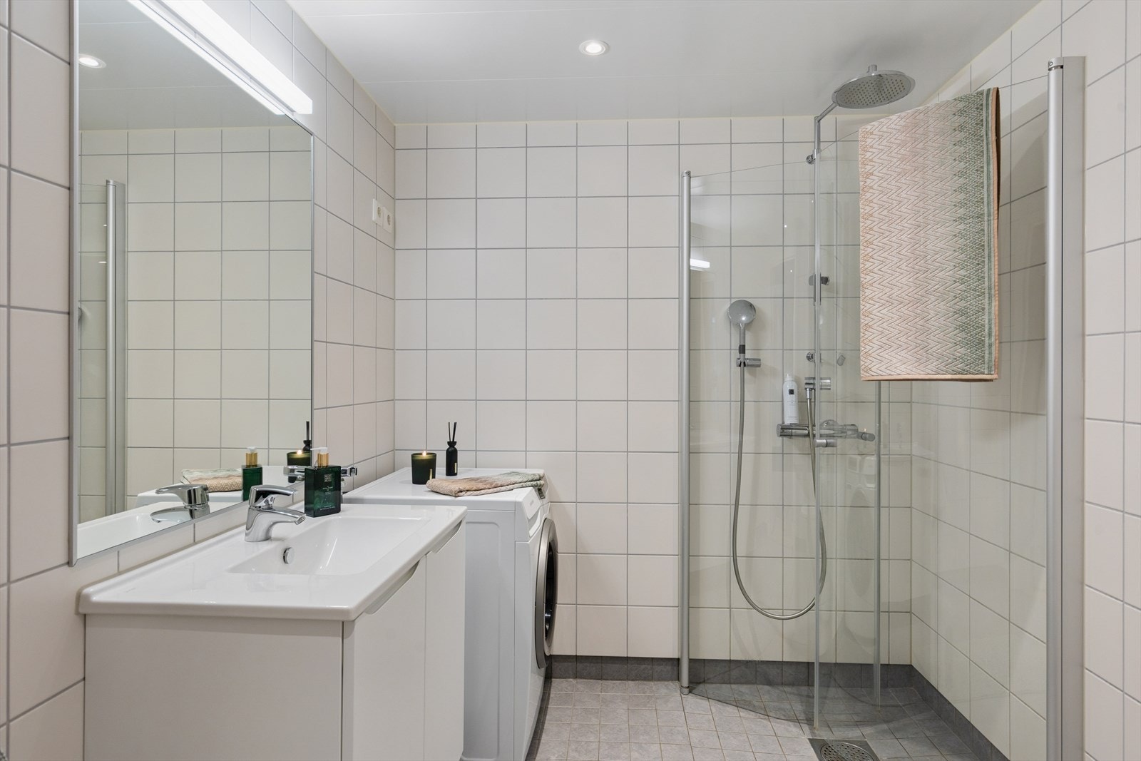 Stilrent bad med flislagte flater, dusjhjørne og varmekabler. Galleribilde