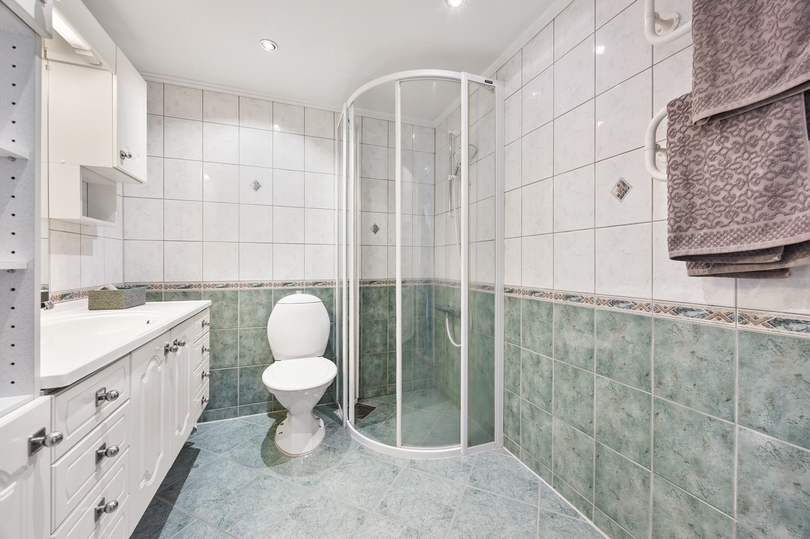 Rommet er utstyrt med dusjhjørne, toalett og elektriske varmekabler i gulvet. Galleribilde