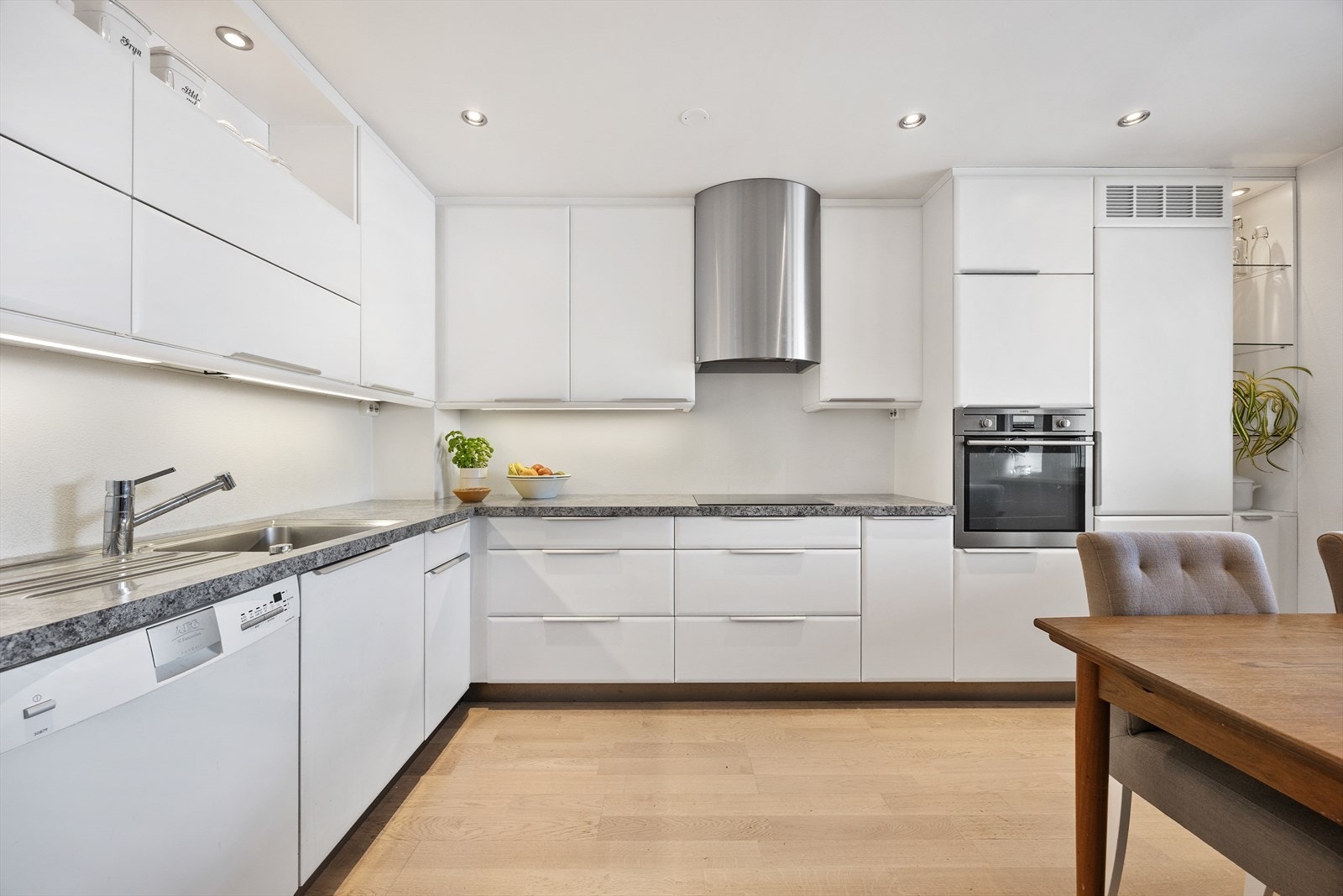 Kjøkkenet har en moderne innredning med glatte fronter og integrerte hvitevarer. Galleribilde