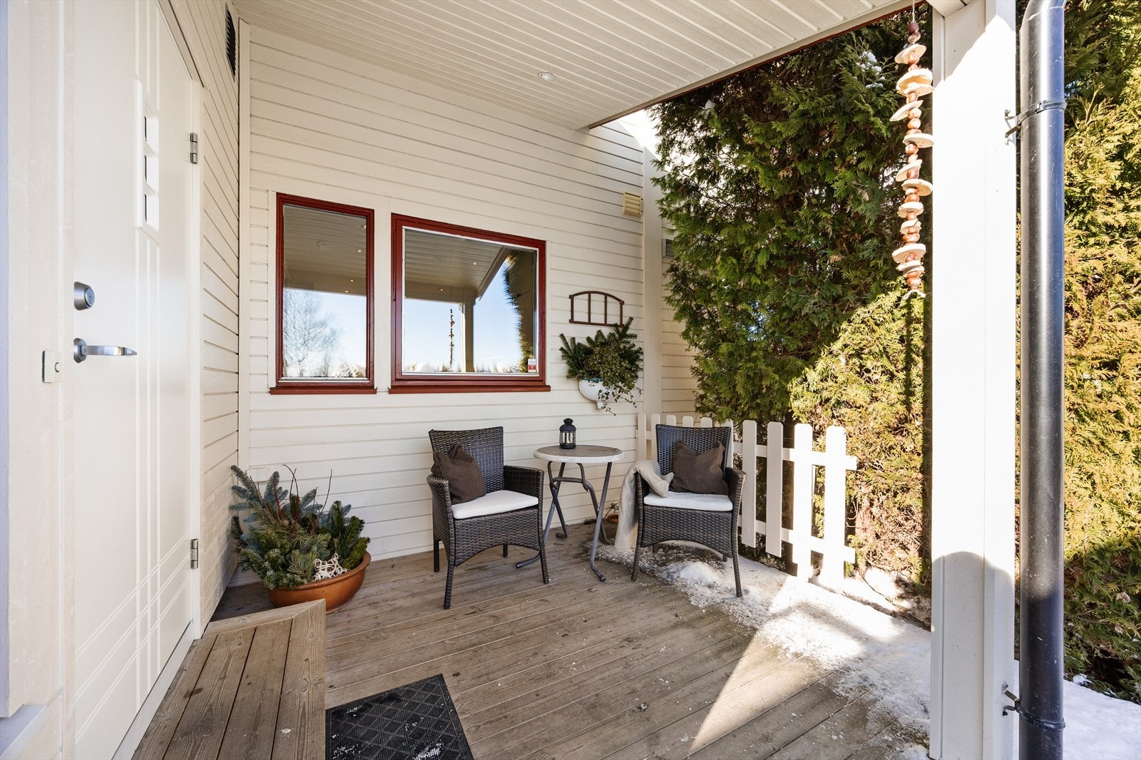 Overbygd inngangsparti med plass til en liten sittegruppe. Galleribilde