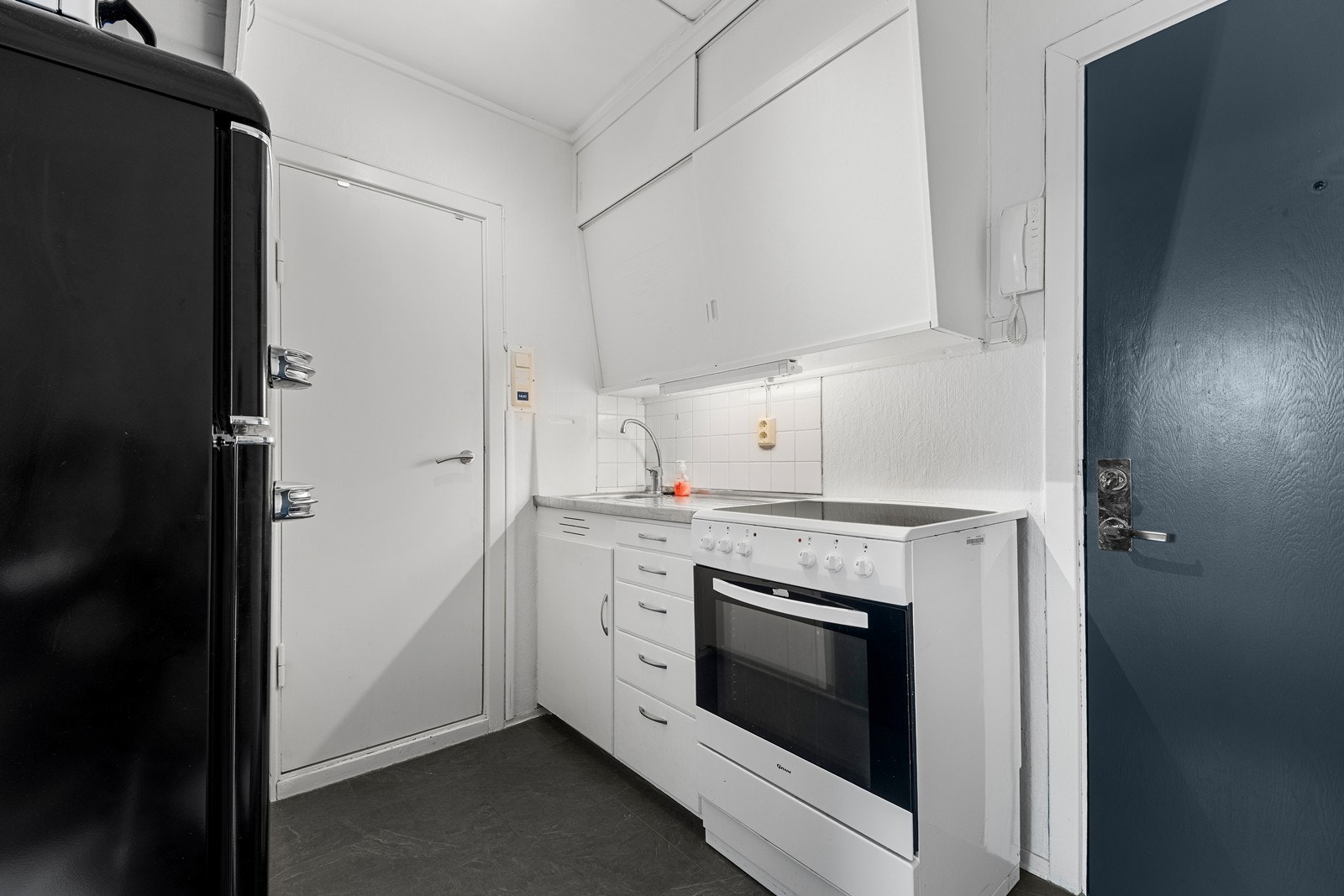 Kjøkkenet har glatte fronter og gode oppbevaringsmuligheter Galleribilde