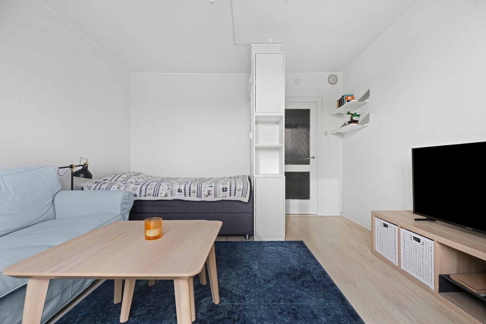 Praktisk planløsning deler leiligheten sømløst inn i ulike soner - her har man god plass til en dobbeltseng og en sofagruppe Galleribilde