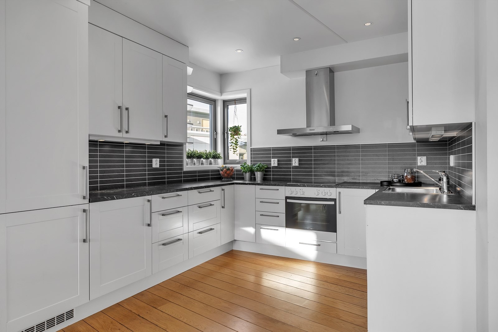 Pent og tidløst kjøkken med rikelig skap- og benkeplass. Galleribilde