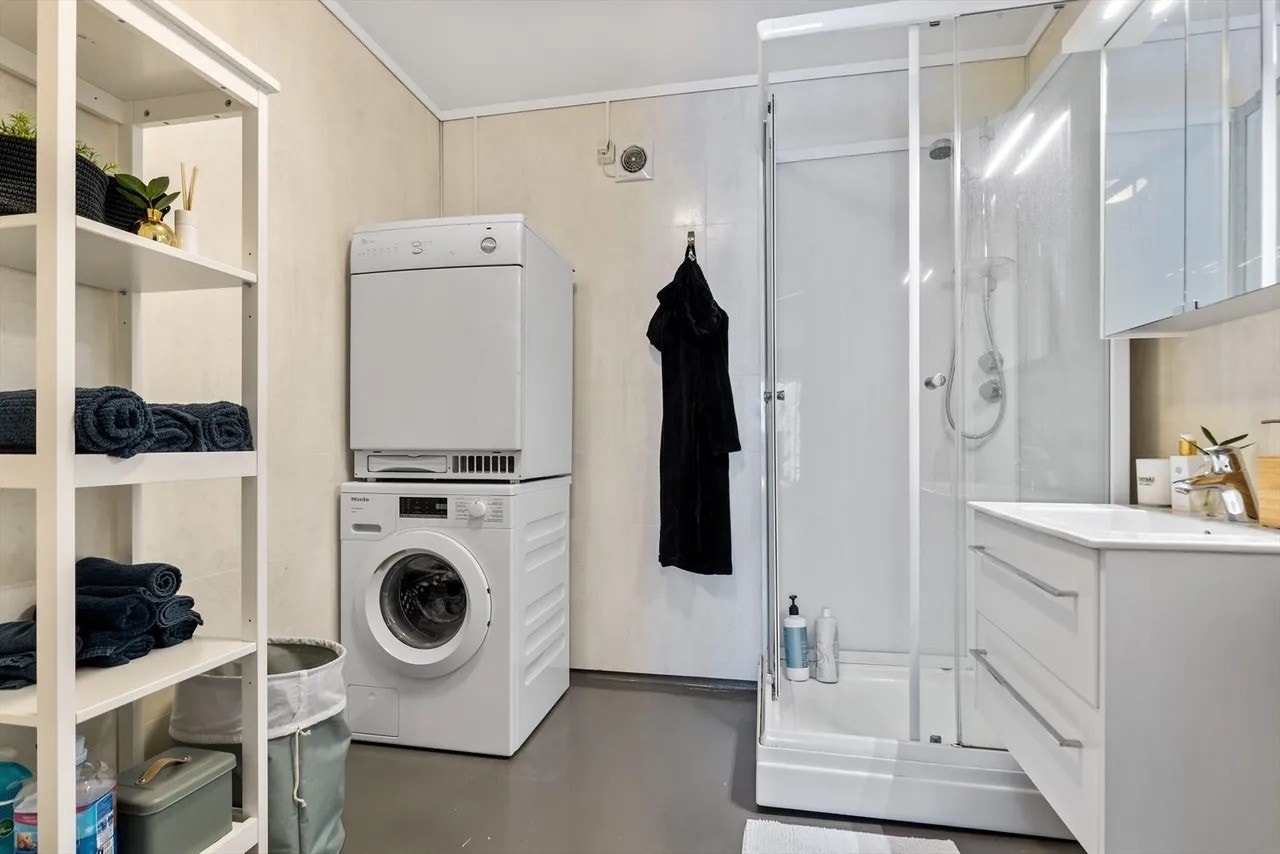 Bad med dusj, og vaskemaskin og tørketrommel. Galleribilde