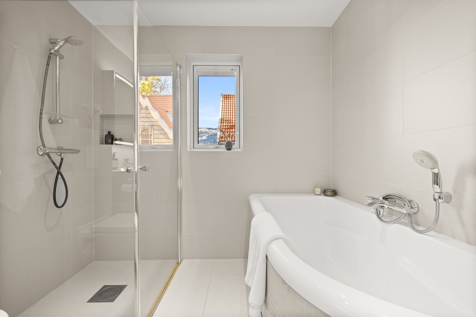 Badet er utstyrt med både dusj og et elegant badekar, som gir en følelse av hverdagsluksus. Galleribilde