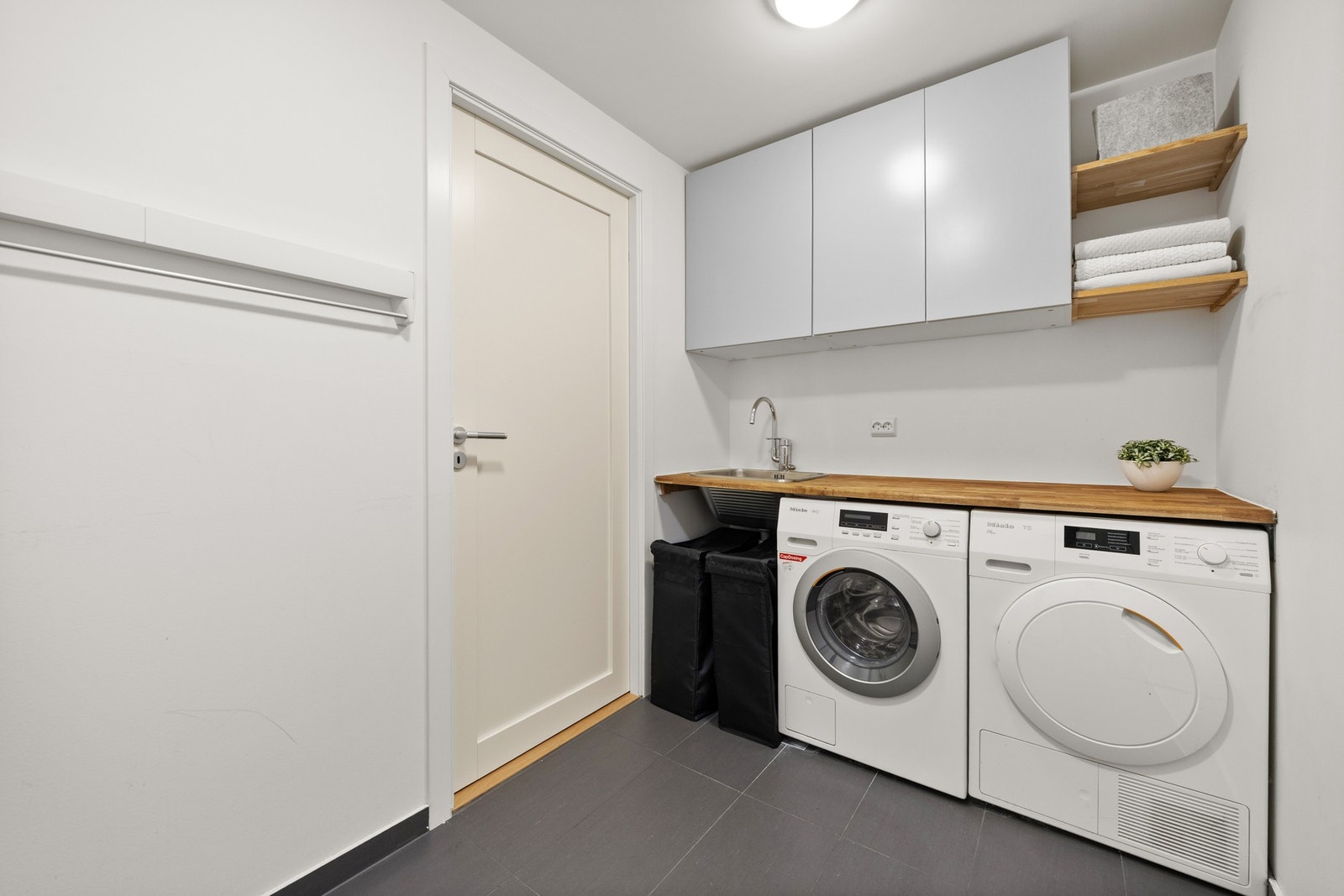 Vaskerommet er praktisk utformet med gode arbeidsflater og rikelig med oppbevaringsplass. Galleribilde