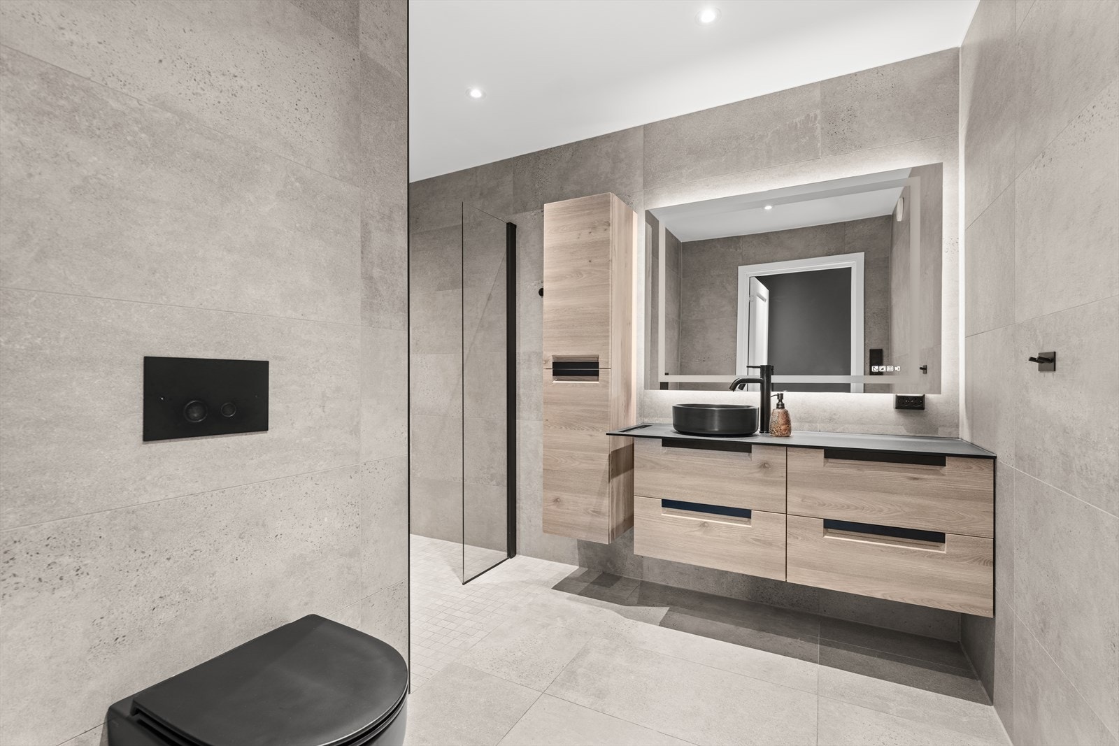 Pent, flislagt bad med generøs dusj, toalett og servant med underskap. Galleribilde