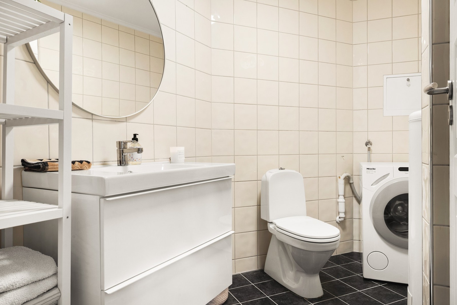 Badet er innredet med baderomsmøbler, servant, toalett og dusjhjørne. Galleribilde