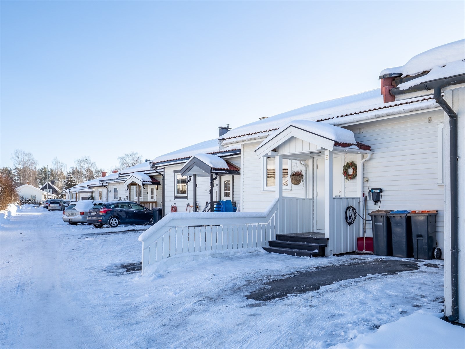 Tomten er pent opparbeidet med asfaltert gårdsplass mot nord og hageanlegg mot syd. Her er det biloppstillingsplass. Galleribilde