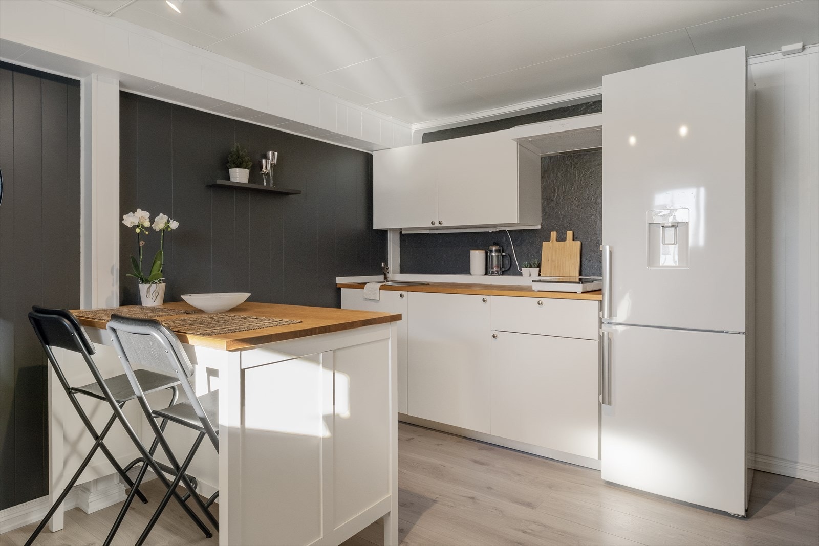 Kjøkkenet er innredet med glatte fronter og en heltre benkeplate med nedfelt vaskekum. Galleribilde