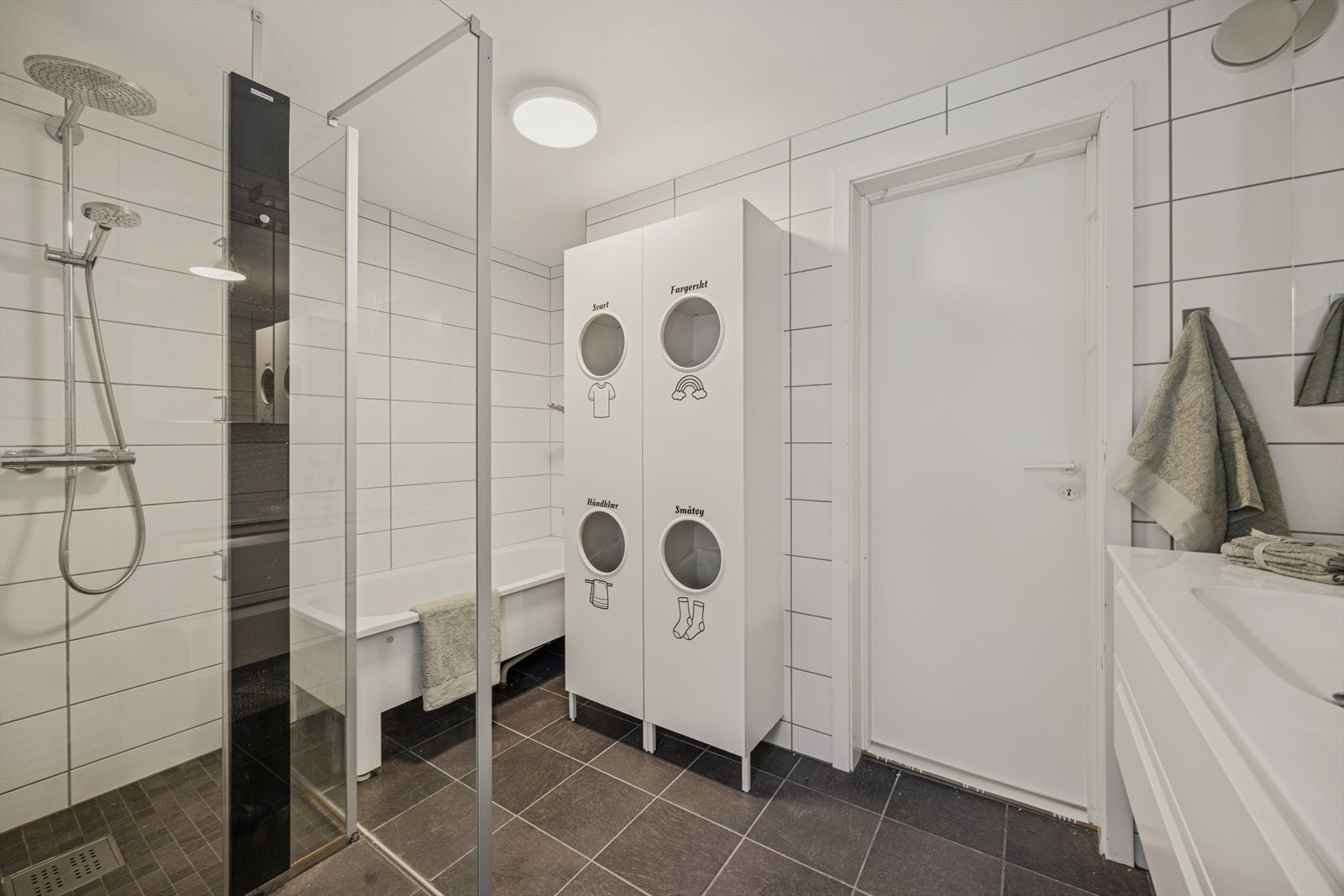 Badet er utstyrt med dusjhjørne med regndusj og hånddusj, samt badekar. Galleribilde