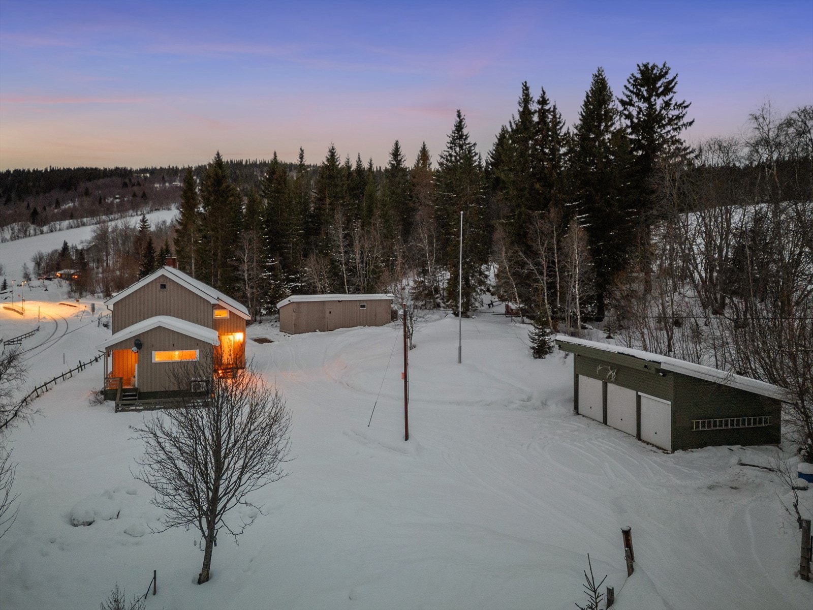 Her får du et stort tun, garasje med tre porter, uthus og flotte hageområder. Galleribilde
