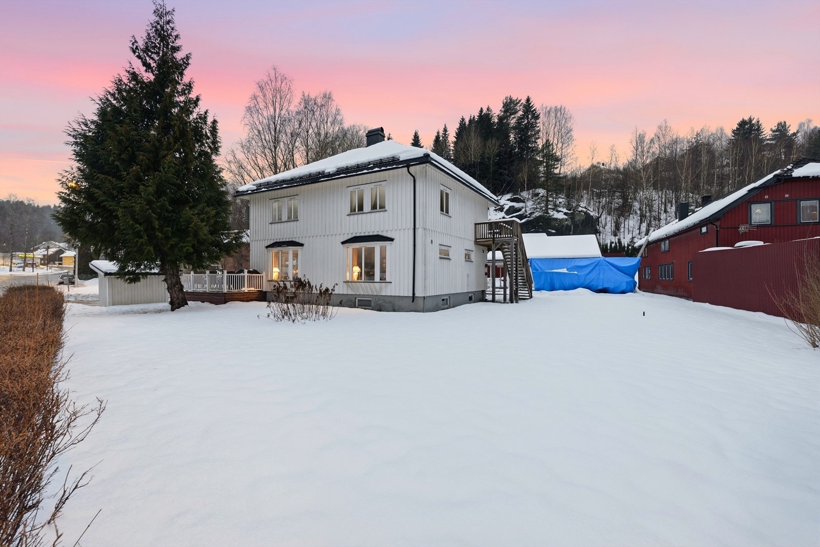 Hageareal i front av huset. Veranda i 2. etasje med trapp opp fra bakkeplan. Galleribilde
