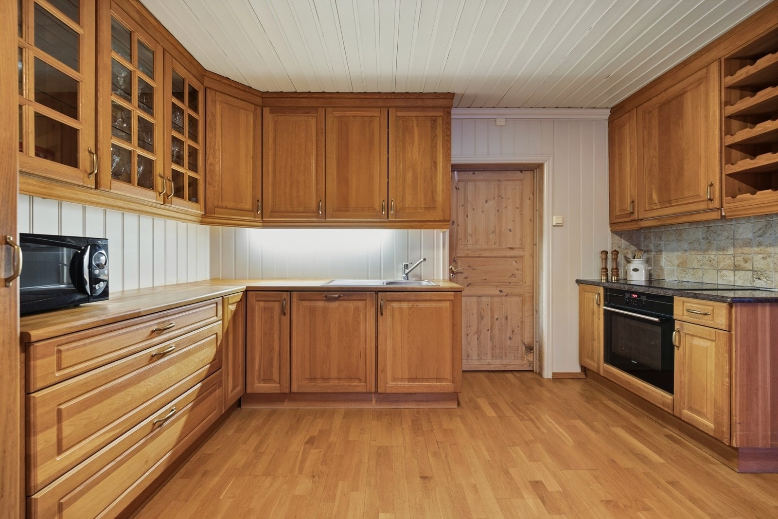 Kjøkkenet har profilert eikeinnredning, heltre benkeplate og nedfelt kum. Galleribilde