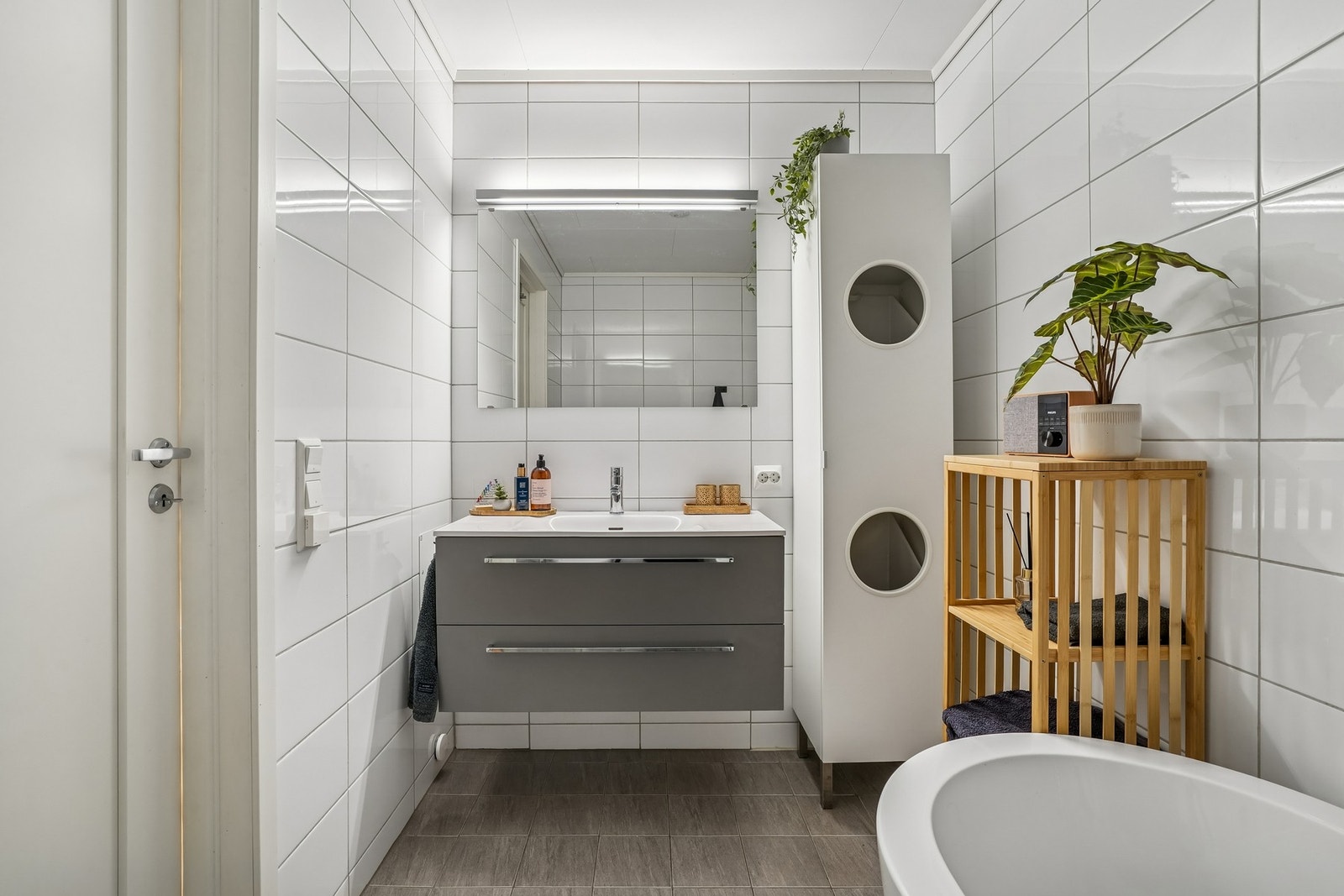 Badet i 1.etasje er helfliset og har elektriske varmekabler i gulvet. Her er det utstyrt med baderomsmøbel med overliggende speil med belysning. Galleribilde