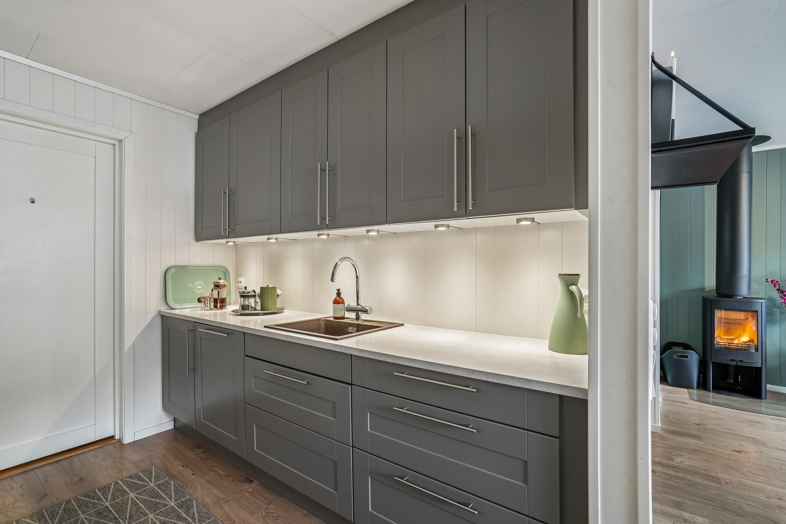 Det er komfyrvakt og vannstoppersystem (byttet i 2026) i skapet under vasken. Galleribilde