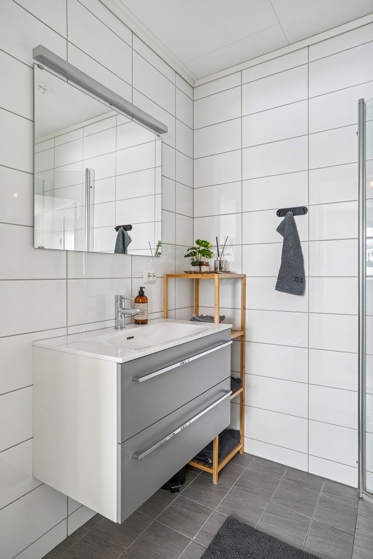 Badet er utstyrt med baderomsmøbel, toalett og dusjhjørne med glassdør. Galleribilde