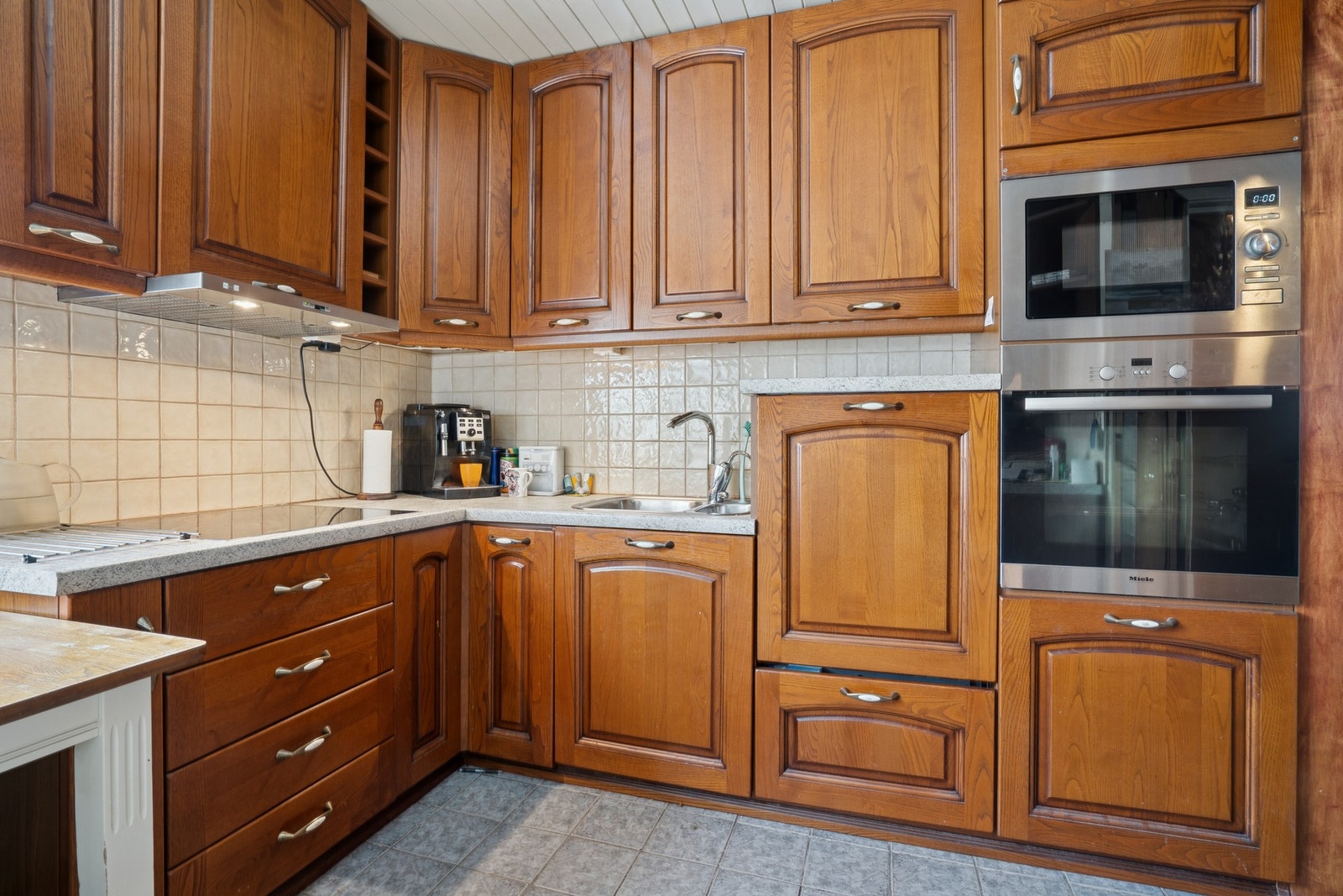 Kjøkken med innredning i treutførelse og laminat benkeplate. Galleribilde