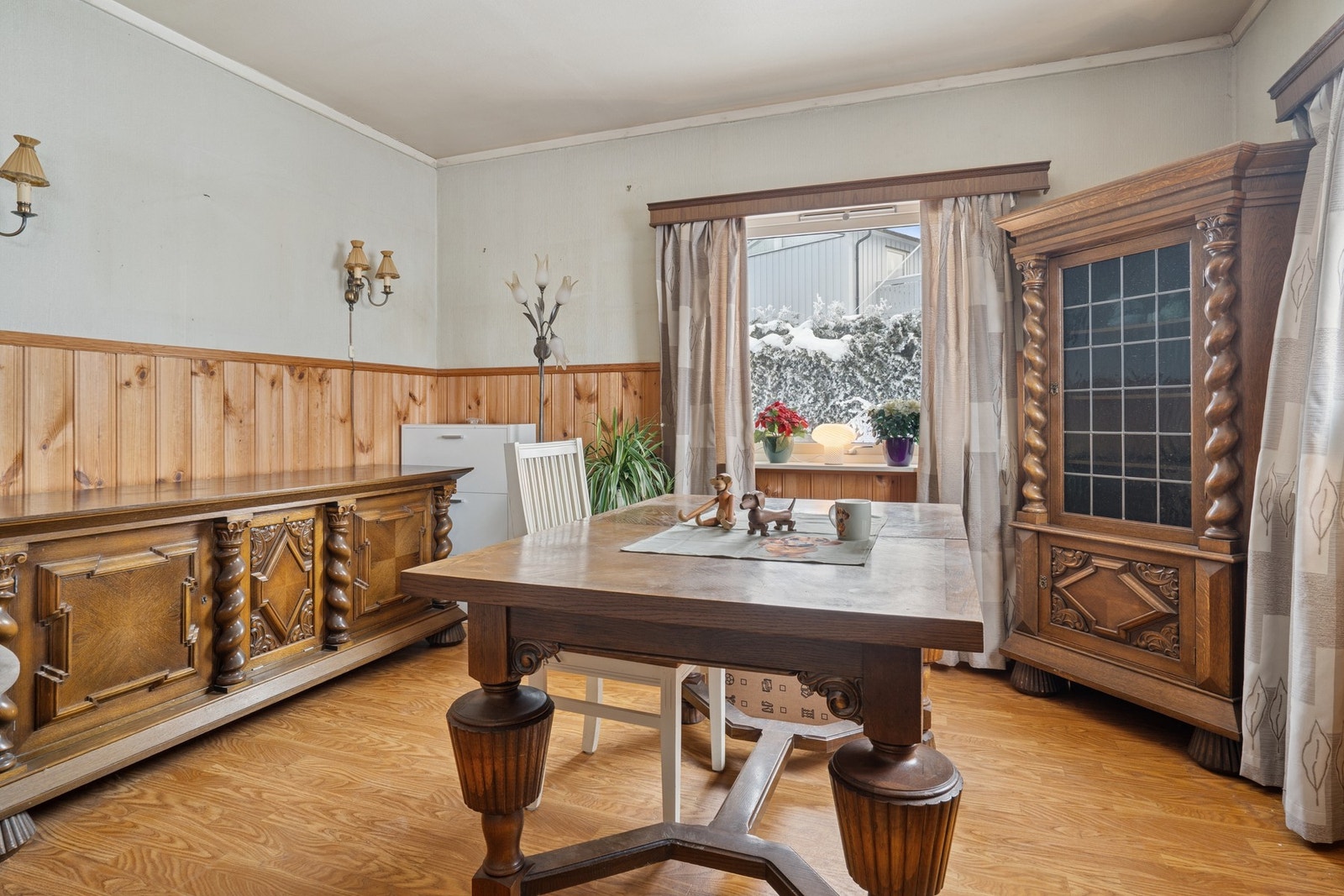 Romslig spisestue med parkett på gulv og malte overflater kombinert med brystpanel på vegger. Galleribilde