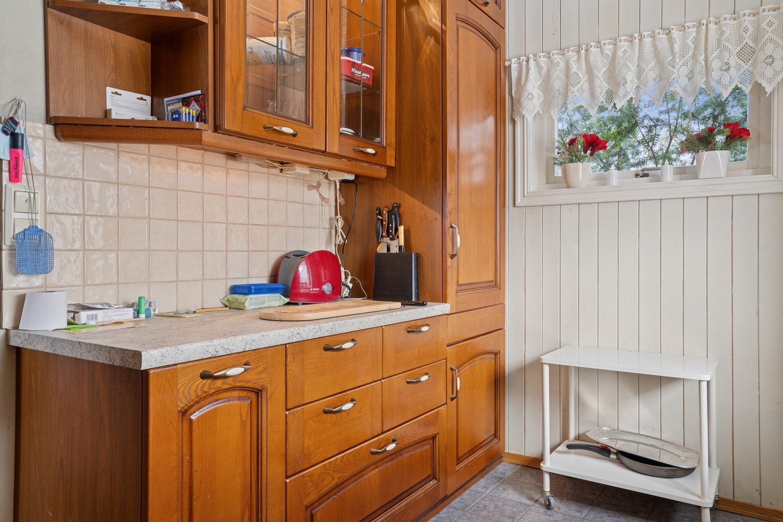 Fliser over benk og plass til frittstående hvitevarer og spiseplass. Galleribilde