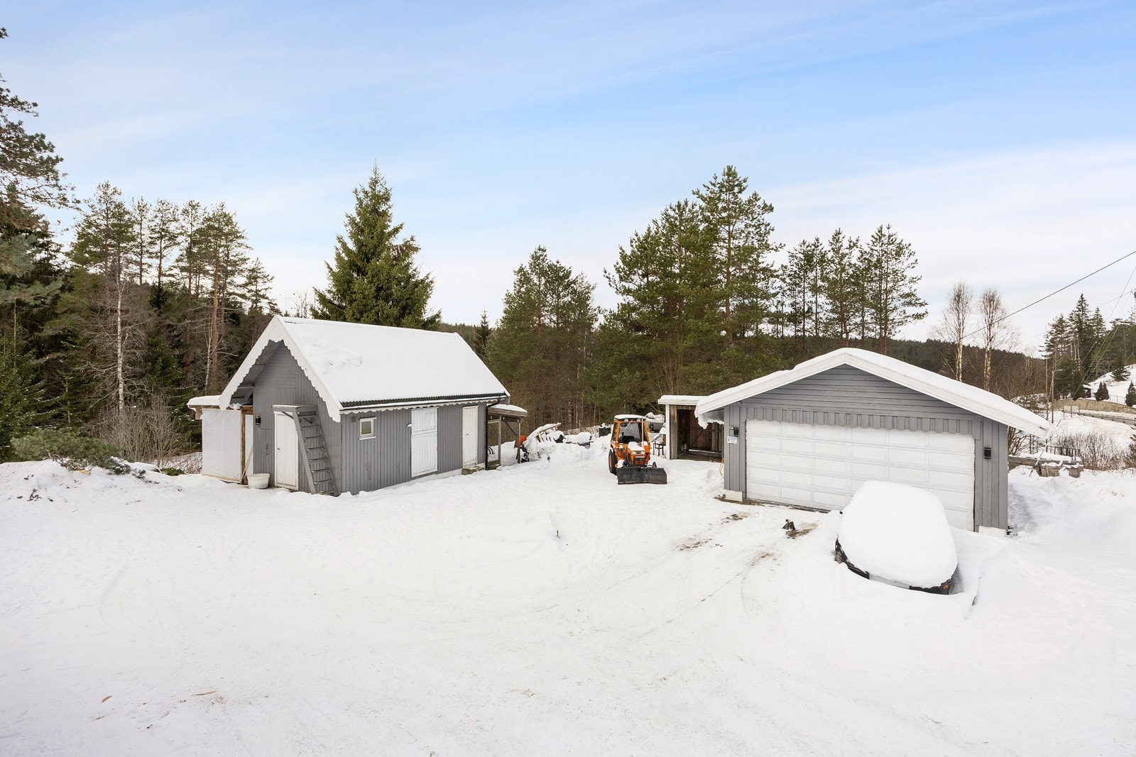 Det er parkering i en frittliggende dobbelgarasje på ca. 46 kvm og på en egen, gruslagt gårdsplass. Uthuset består av to rom samt et lagringsloft. Tilknyttet uthuset er det vedskjul og en hønsegård. Galleribilde