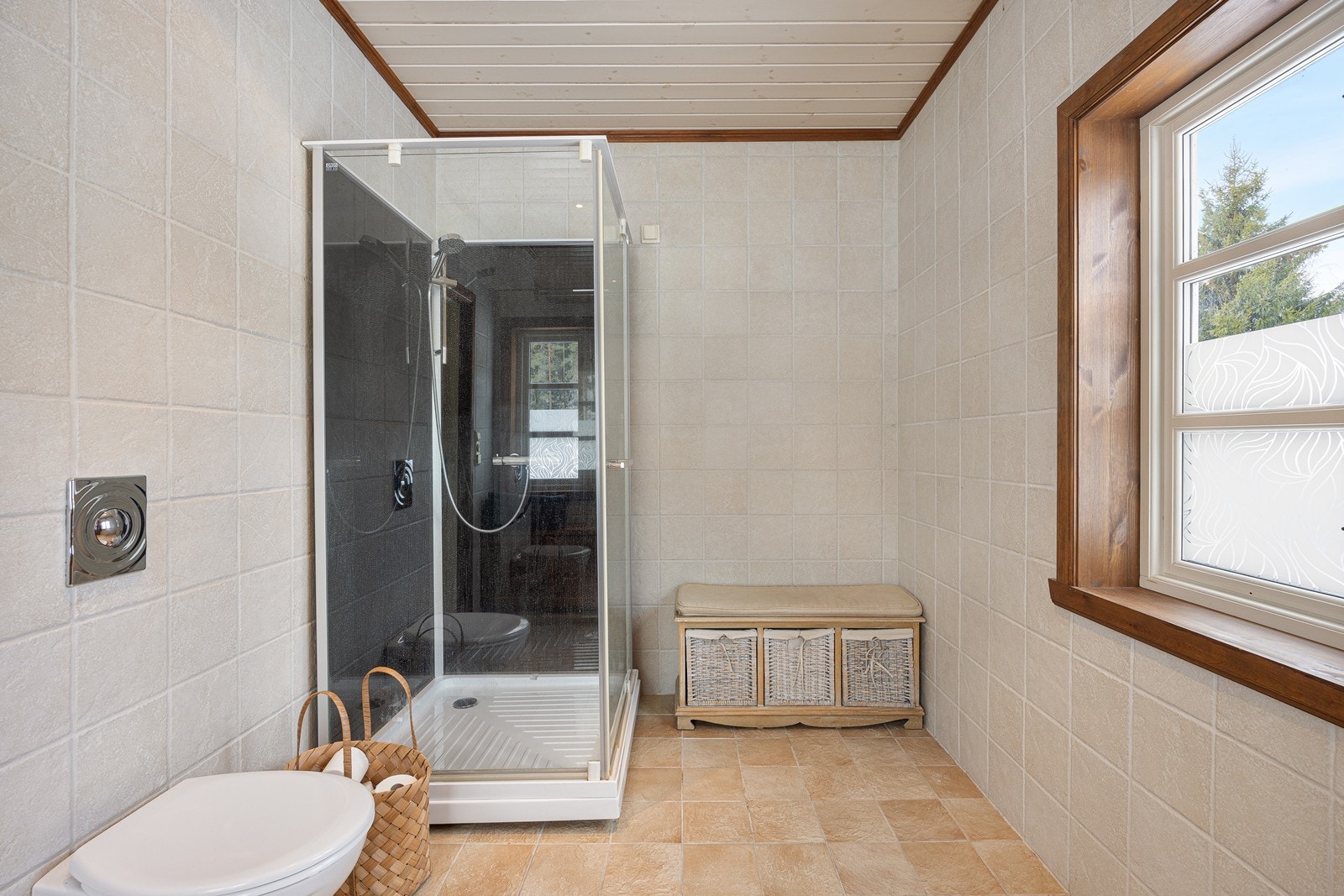 Videre har badet et vegghengt toalett og et dusjkabinett. Galleribilde