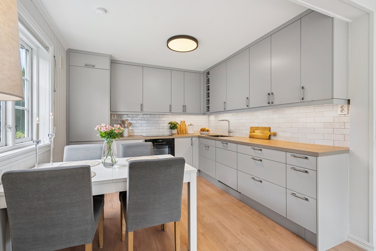 Et tidløst og enkelt kjøkken fra 2023 med lyse glatte fronter og benkeplate av laminat Galleribilde