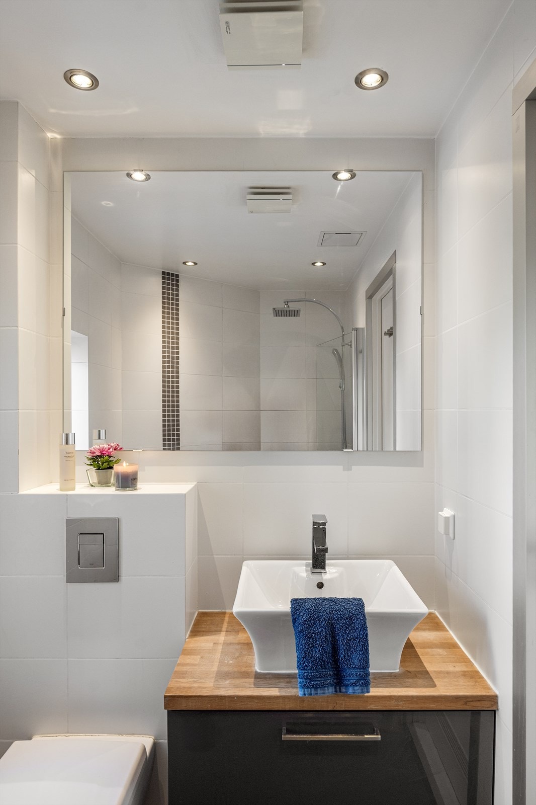 Badet er forøvrig innredet med vegghengt toalett, dusj med innfellbare dusjvegger og servant på skuffeinnredning. Galleribilde