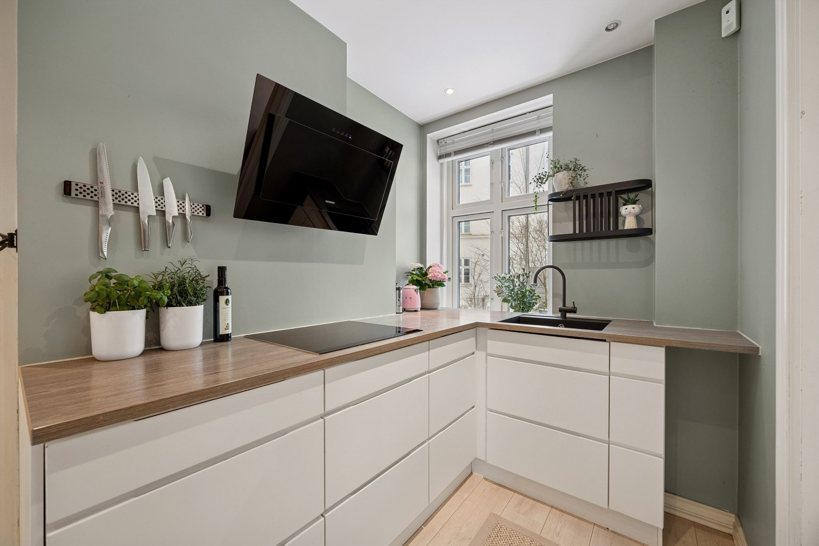 Lys og innbydende kjøkkeninnredning fra KVIK med integrerte hvitevarer. Galleribilde