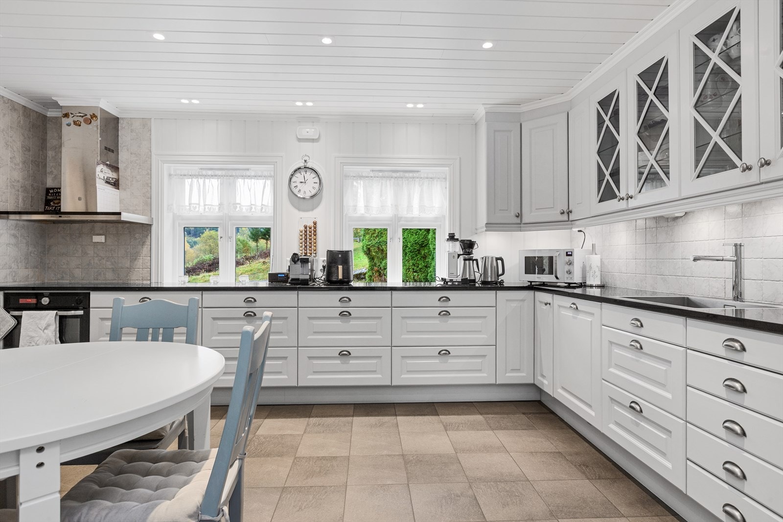 Nyere kjøkkeninnredning med integrerte hvitevarer og godt med skap- og benkeplass Galleribilde