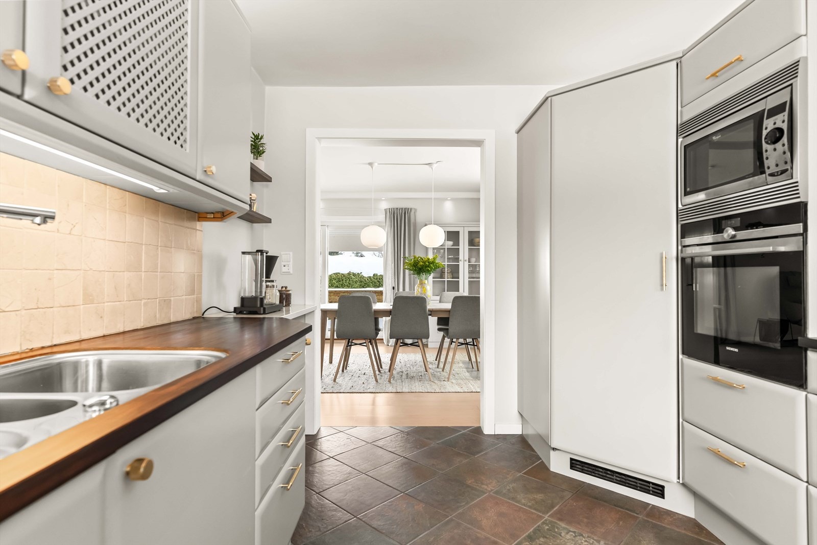 Integrerte hvitevarer og praktiske løsninger gjør kjøkkenet både funksjonelt og ryddig. Her ligger alt til rette for gode matopplevelser. Galleribilde