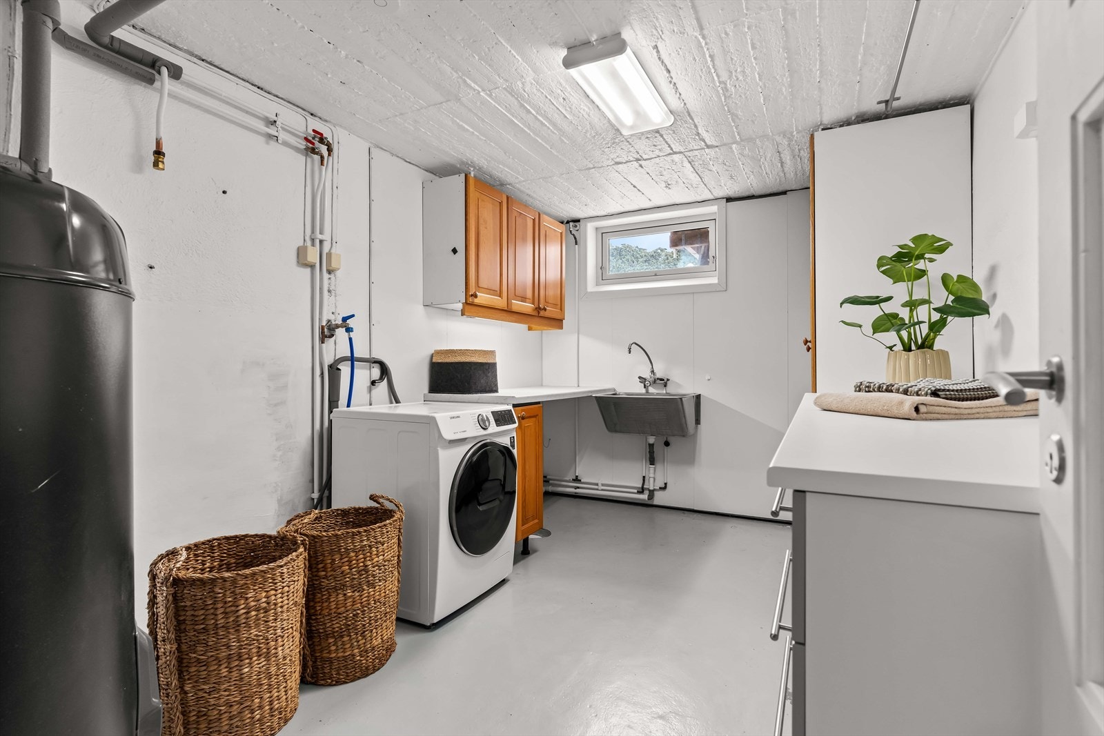 Praktisk vaskerom med god arbeidsplass og opplegg for vaskemaskin. Varmtvannsbereder fra 2022 (Høiax Connected 200). Galleribilde