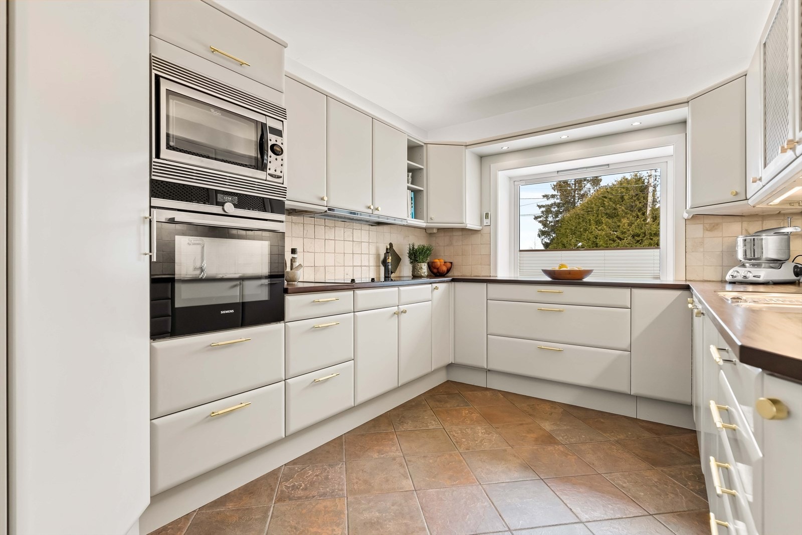 Rikelig med arbeidsflate og godt lys fra vindu gir optimale forhold for matlaging. Fliser og varme i gulv gir ekstra komfort. Galleribilde