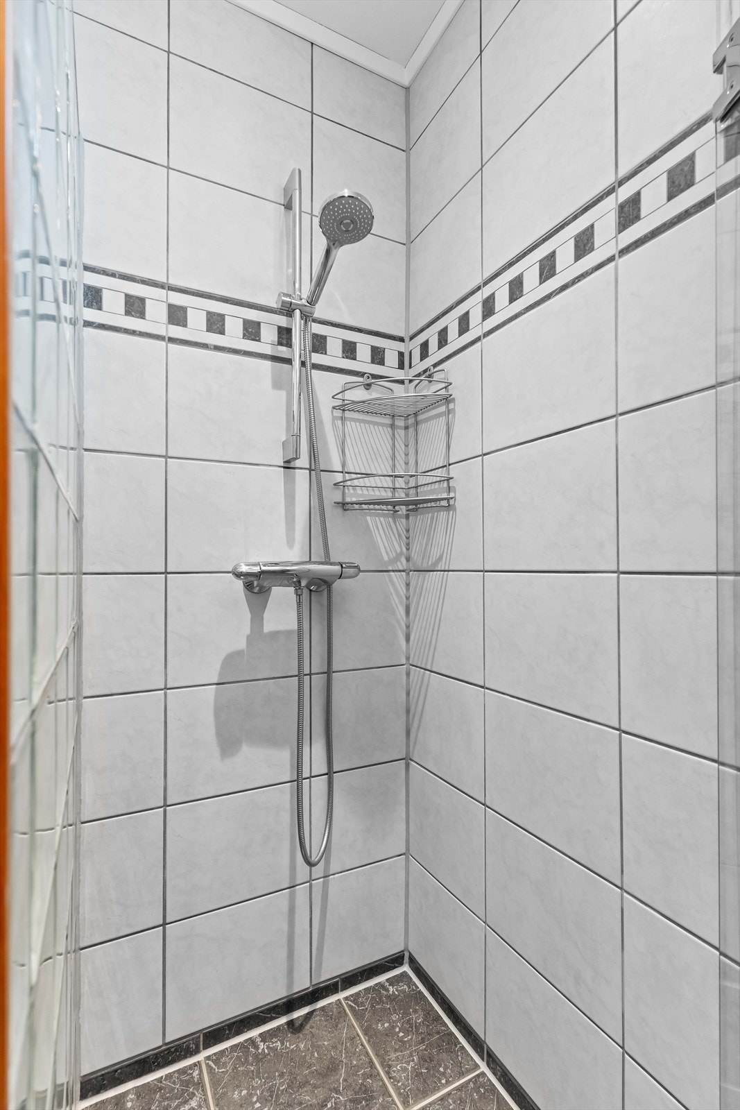 Romslig dusjsone og funksjonell innredning gjør morgenrutinen effektiv. Flislagt gulv med varme. Galleribilde