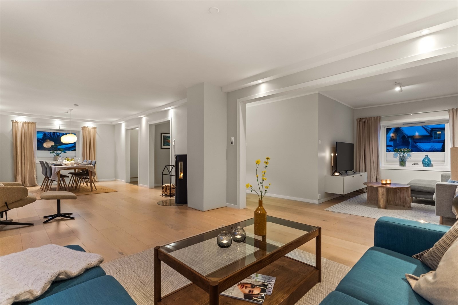 Stuen byr på generøse flater og en lun atmosfære - et naturlig samlingspunkt for både hverdag og fest. Store vindusflater slipper lyset vakkert inn. Foto: Anders Botnmark Galleribilde