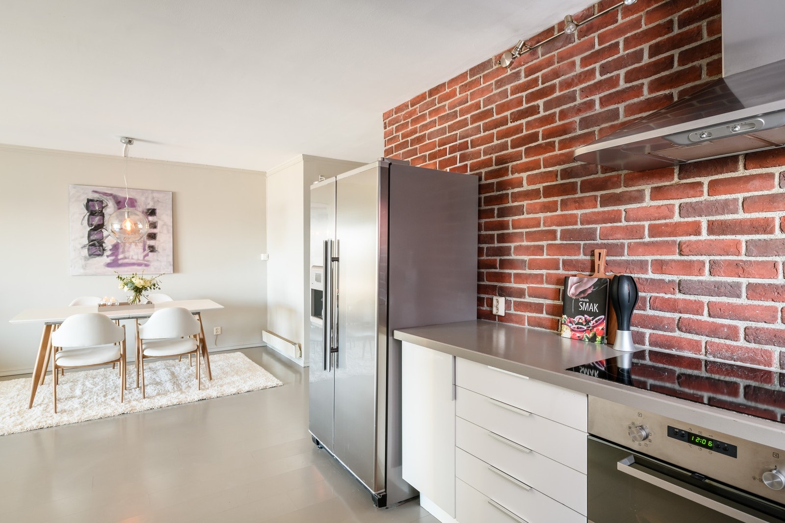 Kjøkkenet gar åpen løsning mot stuen, med en eksponert teglsteinsvegg som gir karakter. Galleribilde