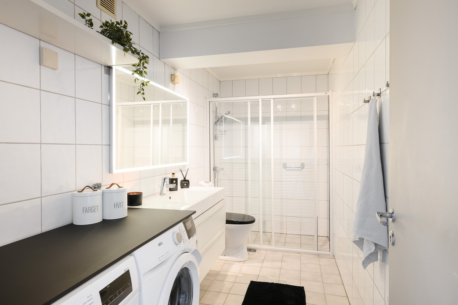 Badet er flislagt, har varme i gulvet og en praktisk dusjnisje med skyvedør. Galleribilde