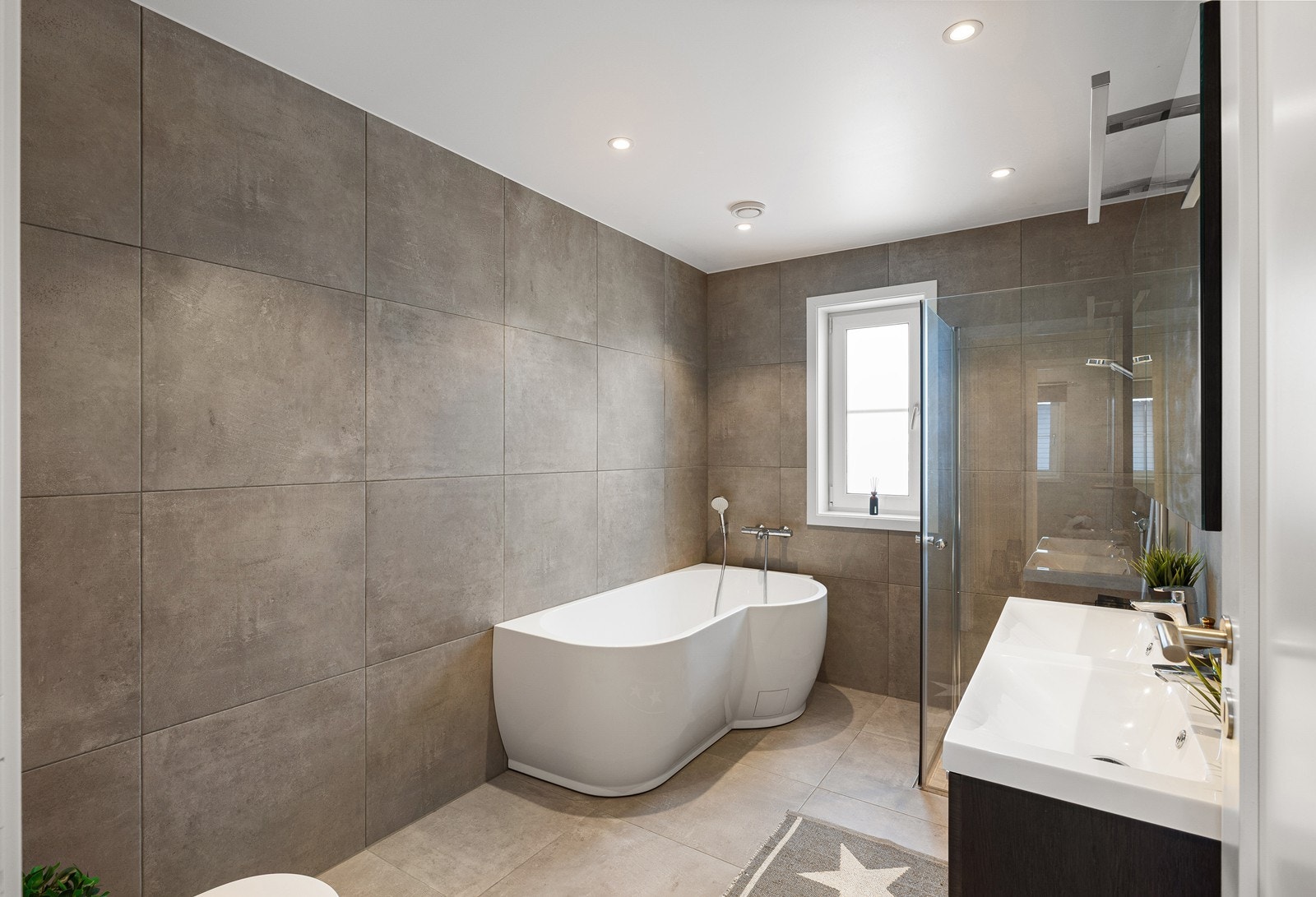 Innredningen består av et underskap/overskap, servant, vannklosett, speil, lys, dusjsone samt ett badekar. Galleribilde