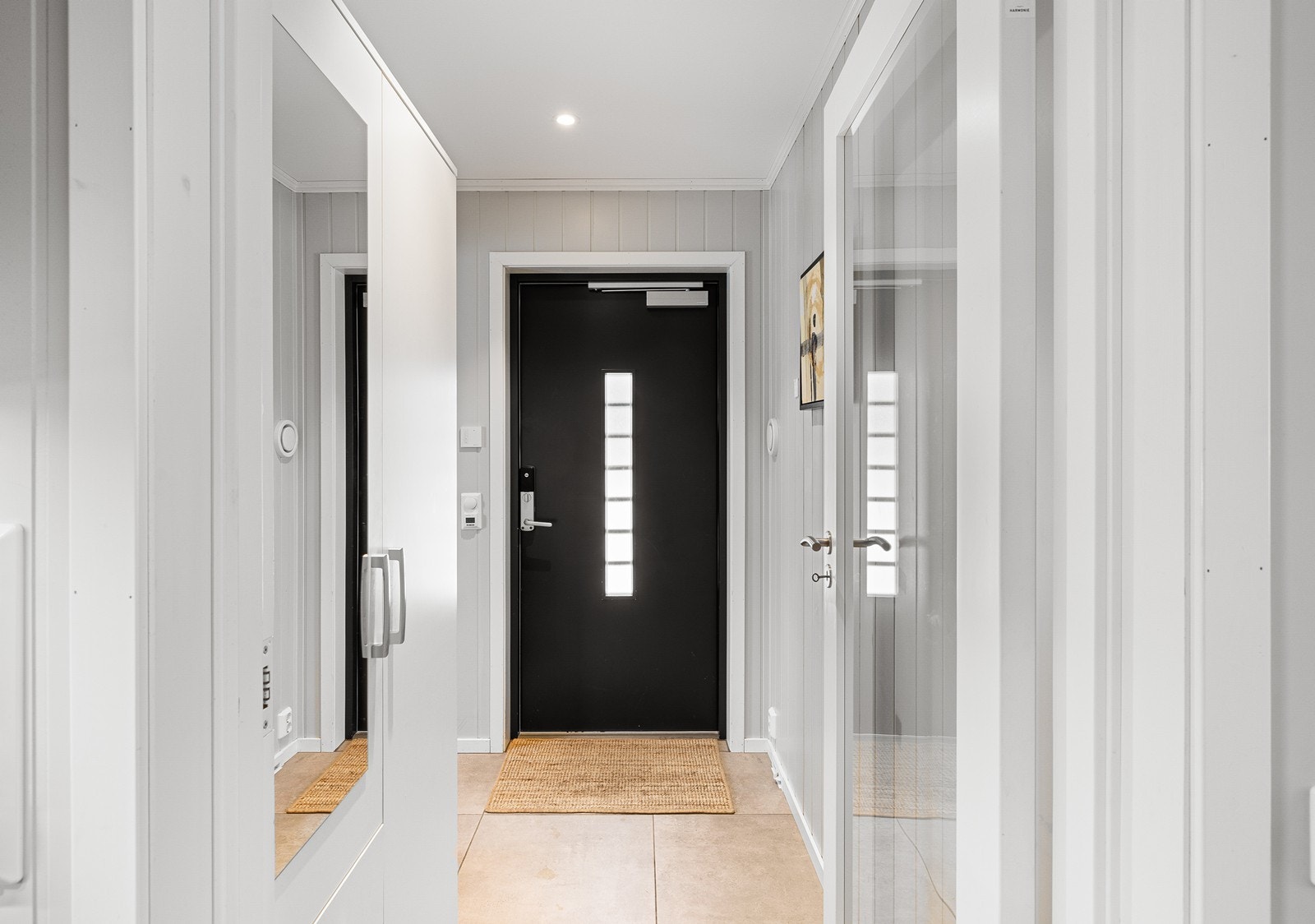 Vel inne i entréen er det plass til å henge fra seg yttertøy i garderobeskap. Det er fliser på gulvet. Galleribilde