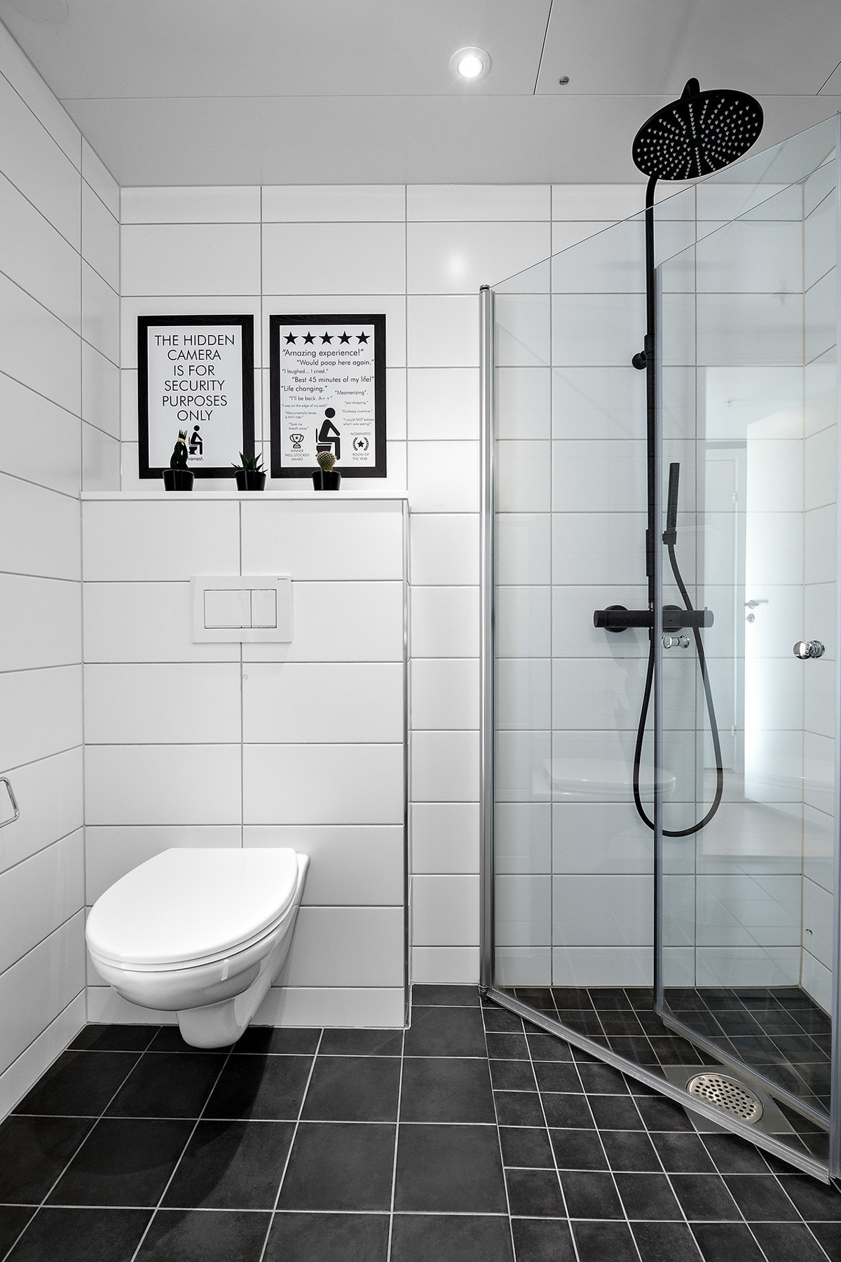 Badet består av enkel servant med skuffer, speil med belysning, vegghengt wc, inn -og utadslående dusjdører og regnfalls dusj. Galleribilde