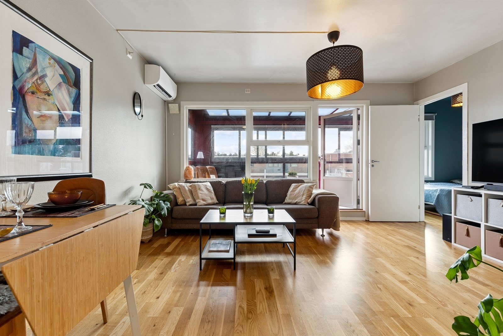 Leiligheten er lysmalt, med parkett på gulv og store vindusflater Galleribilde