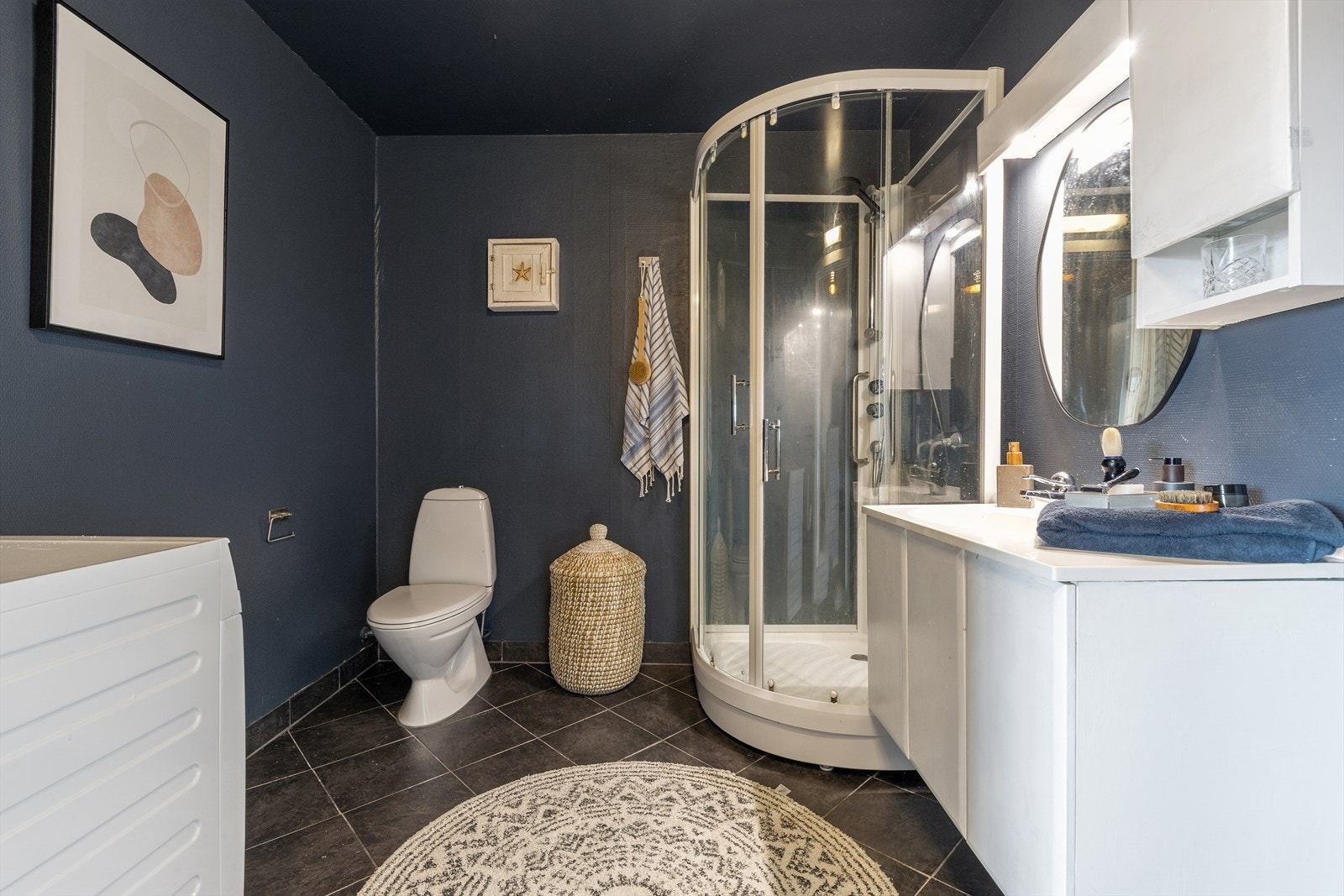 Baderom med fliser på gulv, varmekabler og opplegg for vaskemaskin Galleribilde