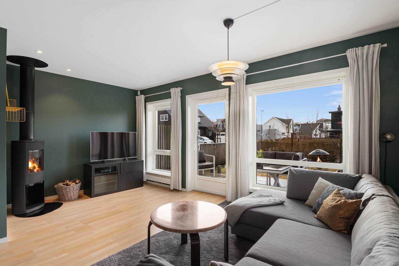 Stuen er malt i en varm og moderne grønnfarge. Vedovn. Galleribilde