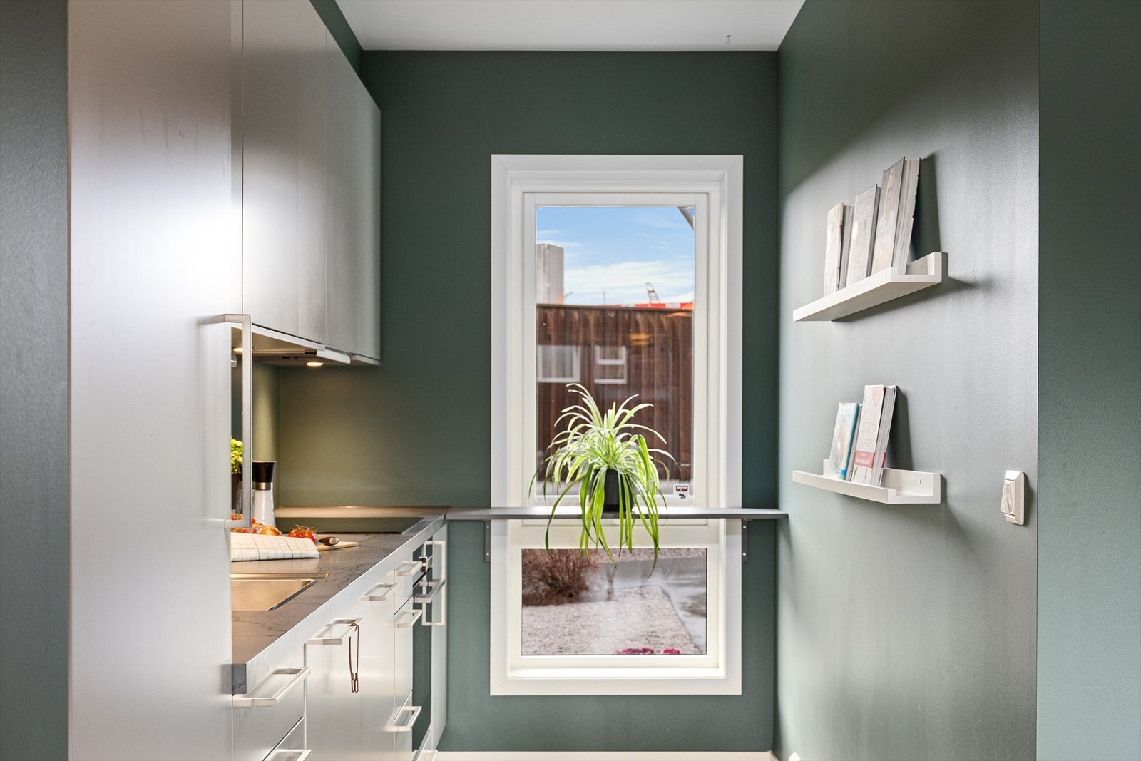 Pent kjøkken med fronter i en lun gråtone. Integrerte hvitevarer som medfølger i salget. Galleribilde